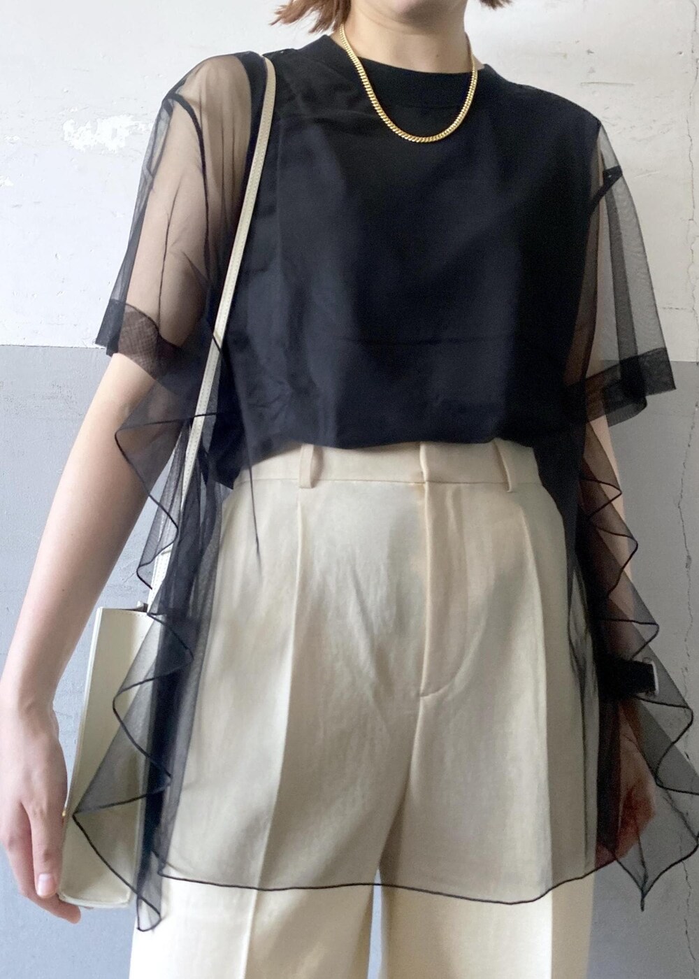 グレー系のショルダーバッグ、ベージュ系のサンダル、ベージュ系のスラックスを着用したレディースの夏コーディネートの6枚目の写真