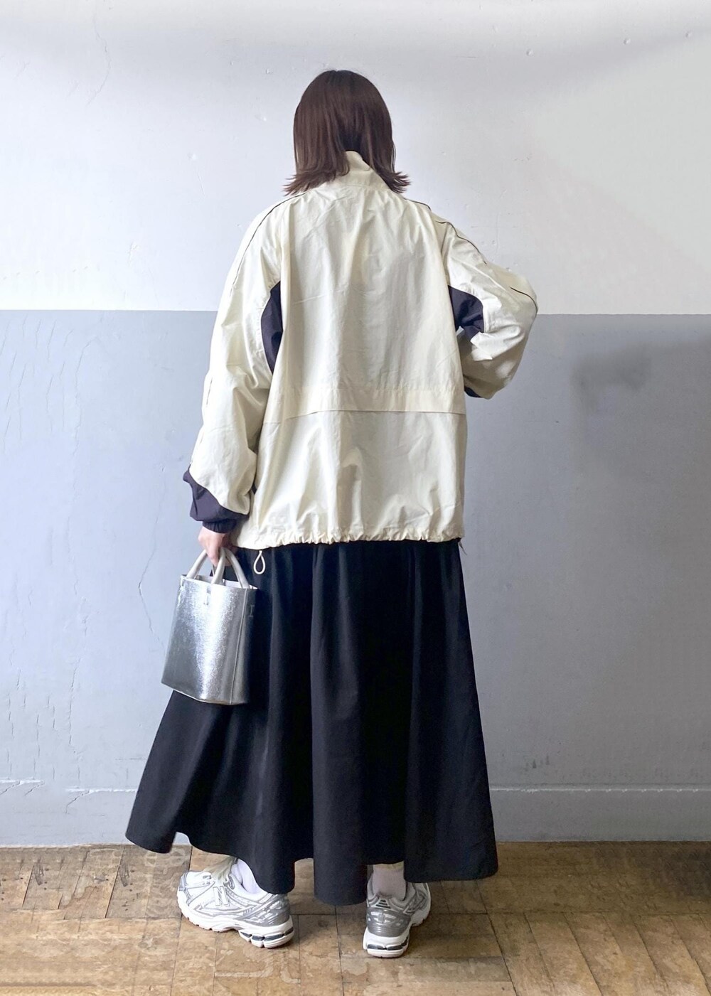 シルバー系のショルダーバッグ、ホワイト系のその他アウター、ブラック系のワンピースを着用したレディースの冬コーディネートの2枚目の写真