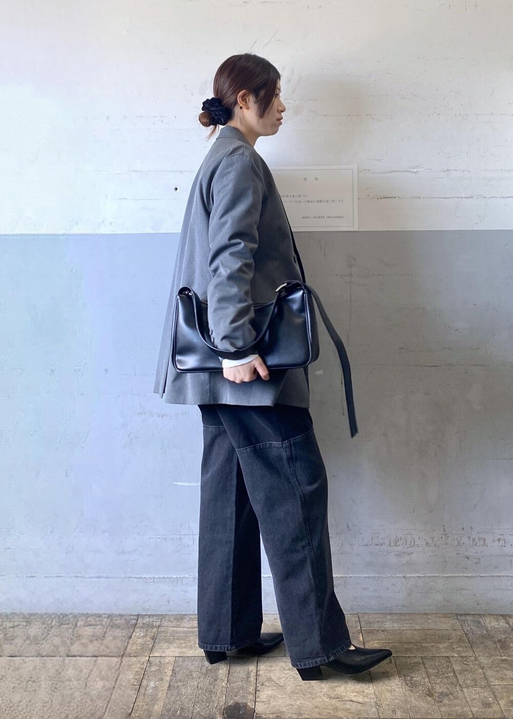 グレー系のテーラードジャケット、ブラック系のパンプス、ブラック系のショルダーバッグを着用したレディースの冬コーディネートの3枚目の写真