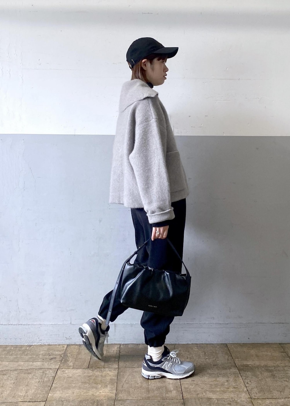 ブラック系のニット/セーター、ベージュ系のカーディガン/ボレロ、ブラック系のハンドバッグを着用したレディースの秋コーディネートの2枚目の写真