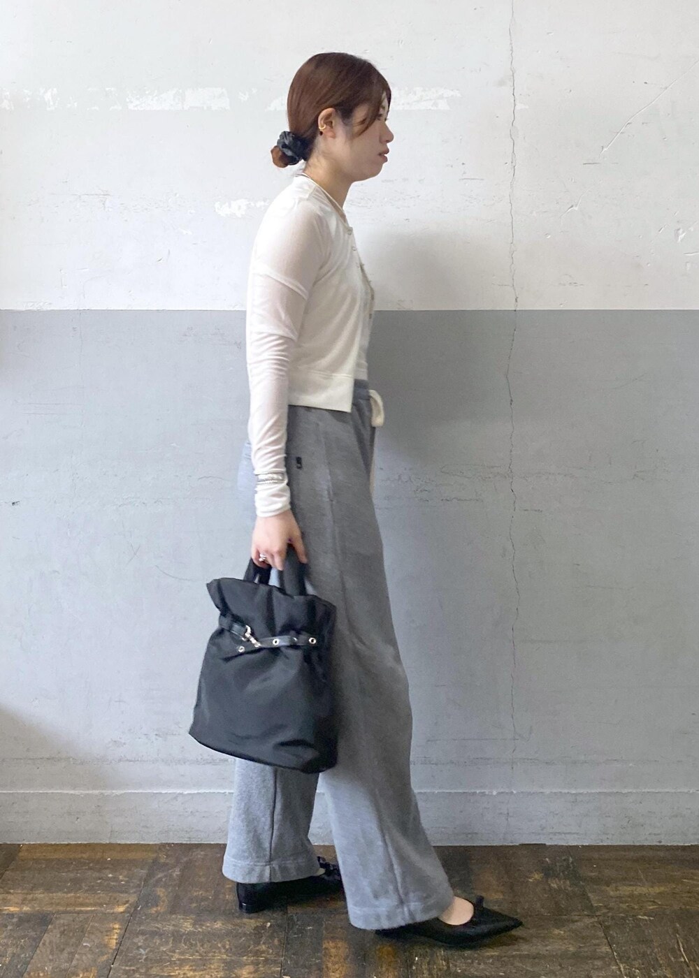 ブラック系のパンプス、ホワイト系のカーディガン/ボレロ、グレー系のスウェットパンツを着用したレディースの秋コーディネートの4枚目の写真