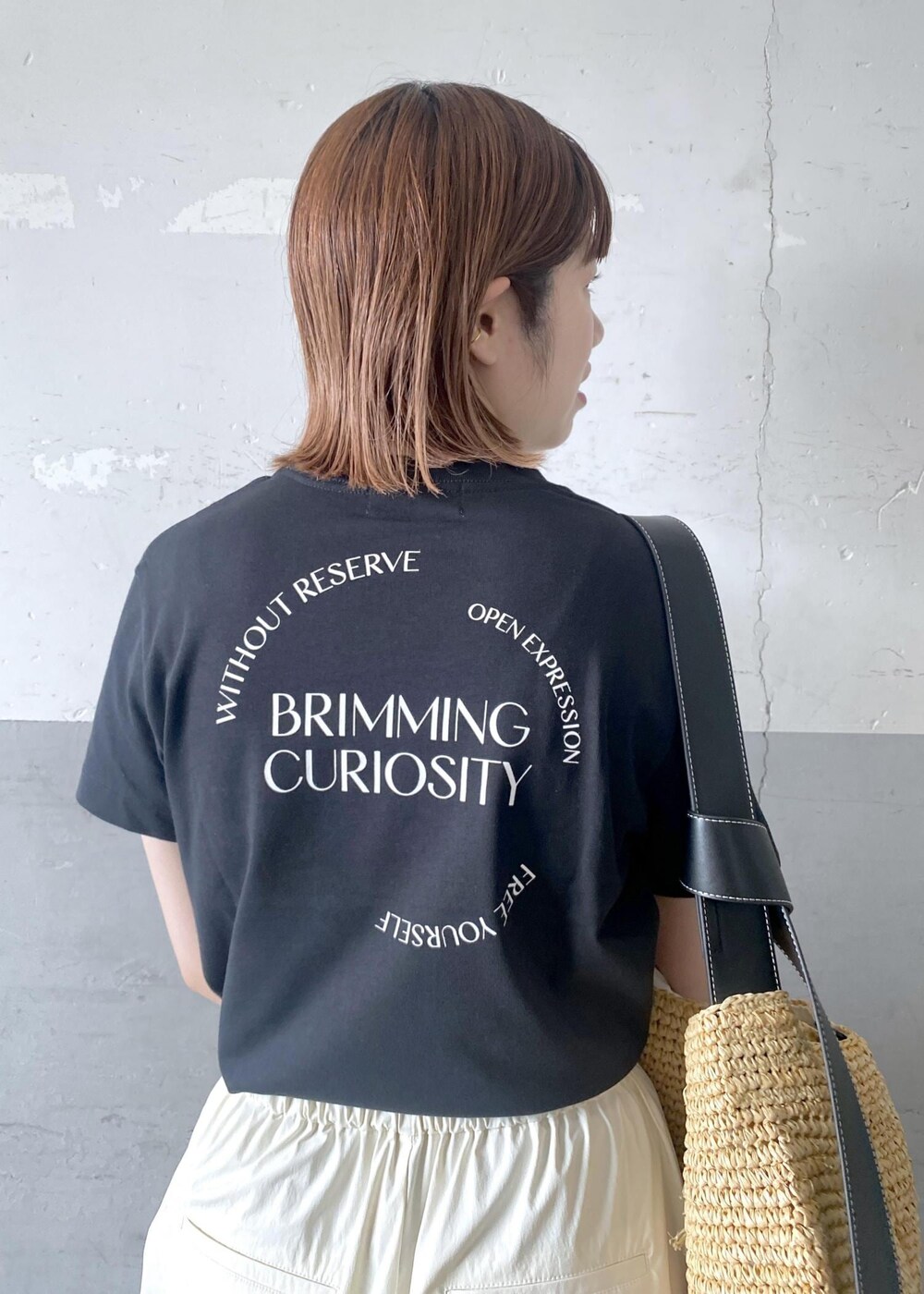 ベージュ系のトートバッグ、ブラック系のTシャツ/カットソー、ブラック系のサンダルを着用したレディースの夏コーディネートの6枚目の写真