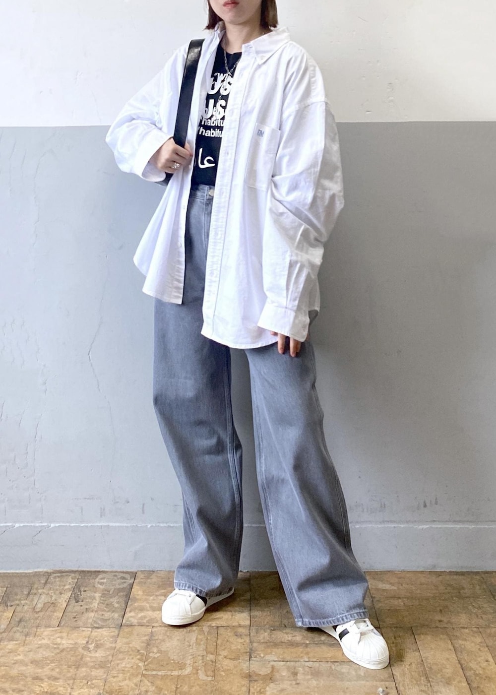 ブラック系のTシャツ/カットソー、ブラック系のショルダーバッグ、ホワイト系のシャツ/ブラウスを着用したレディースの冬コーディネートの8枚目の写真