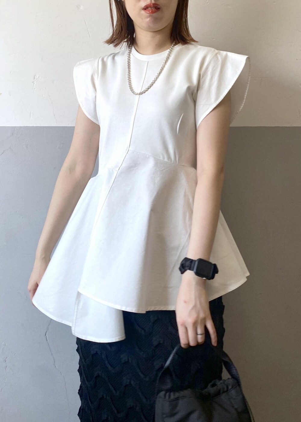 ブラック系のハンドバッグ、グリーン系のサンダル、ブラック系のスカートを着用したレディースの春コーディネートの6枚目の写真