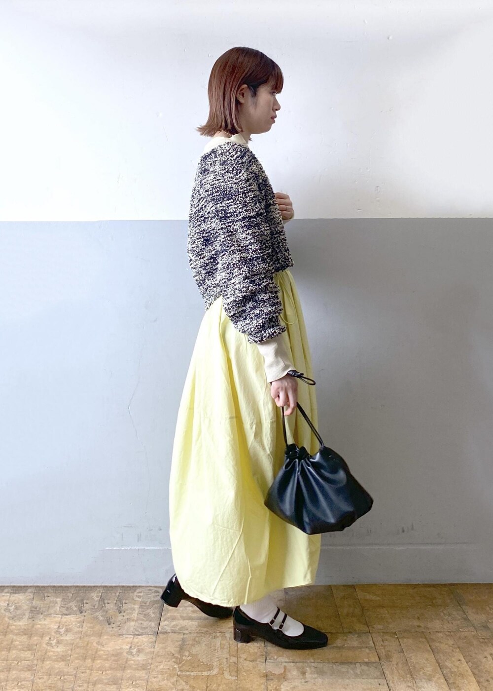 ブラック系のパンプス、ブラック系のショルダーバッグ、ベージュ系のカーディガン/ボレロを着用したレディースの春コーディネートの6枚目の写真