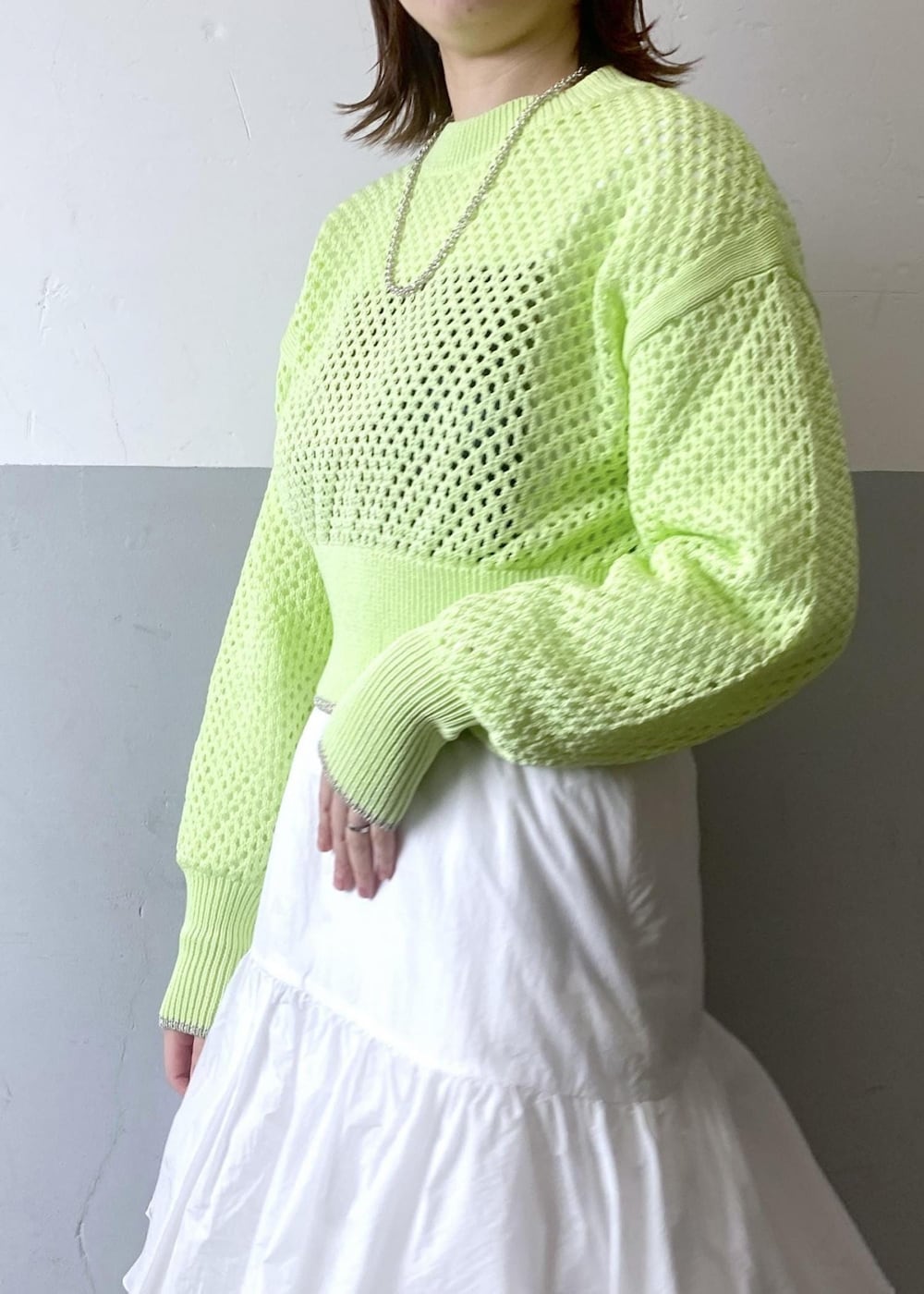 ホワイト系のスカート、ブラック系のブルゾン、グリーン系のニット/セーターを着用したレディースの春コーディネートの7枚目の写真