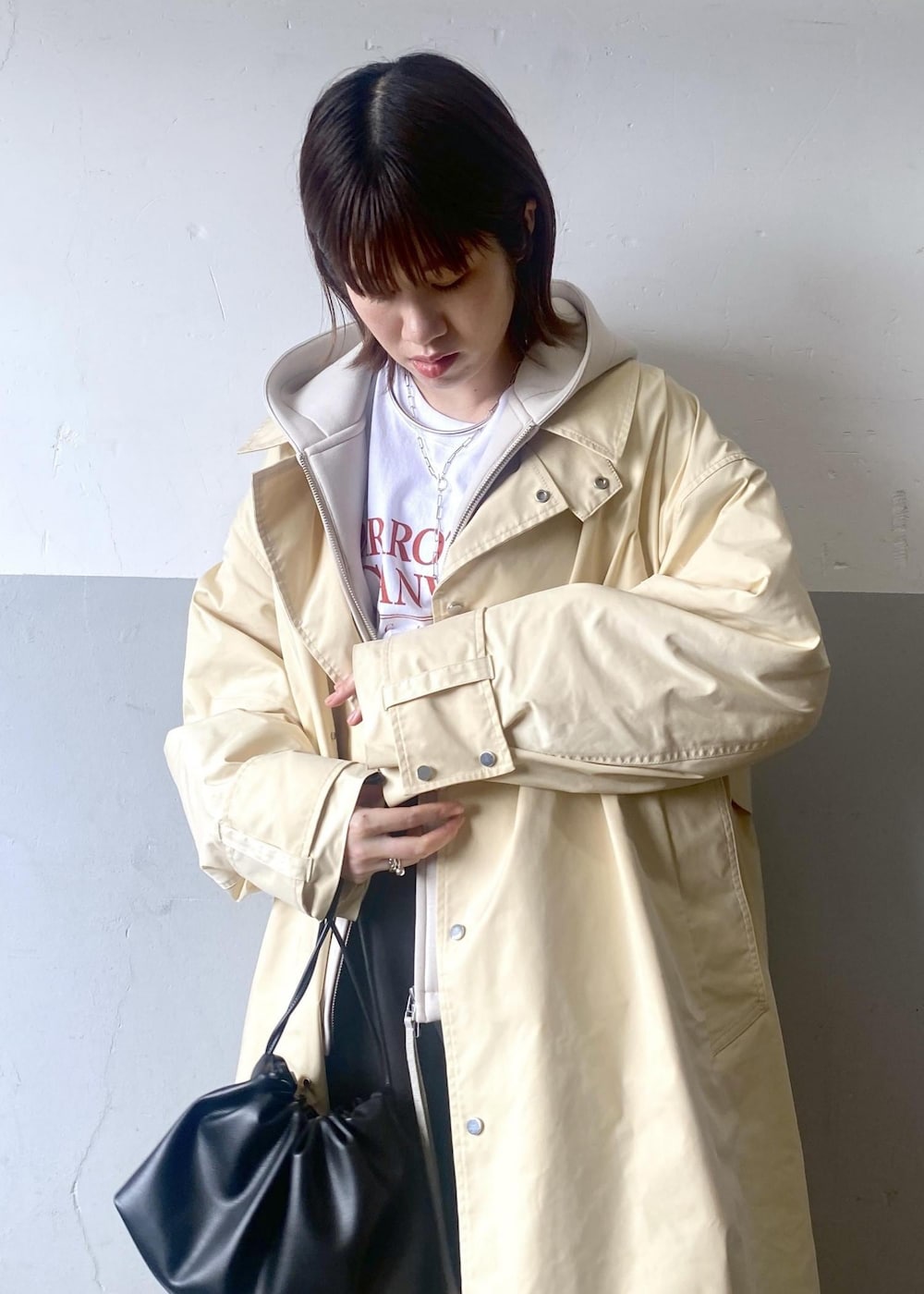 ブラック系のショルダーバッグ、ホワイト系のTシャツ/カットソー、ホワイト系のブルゾンを着用したレディースの春コーディネートの9枚目の写真