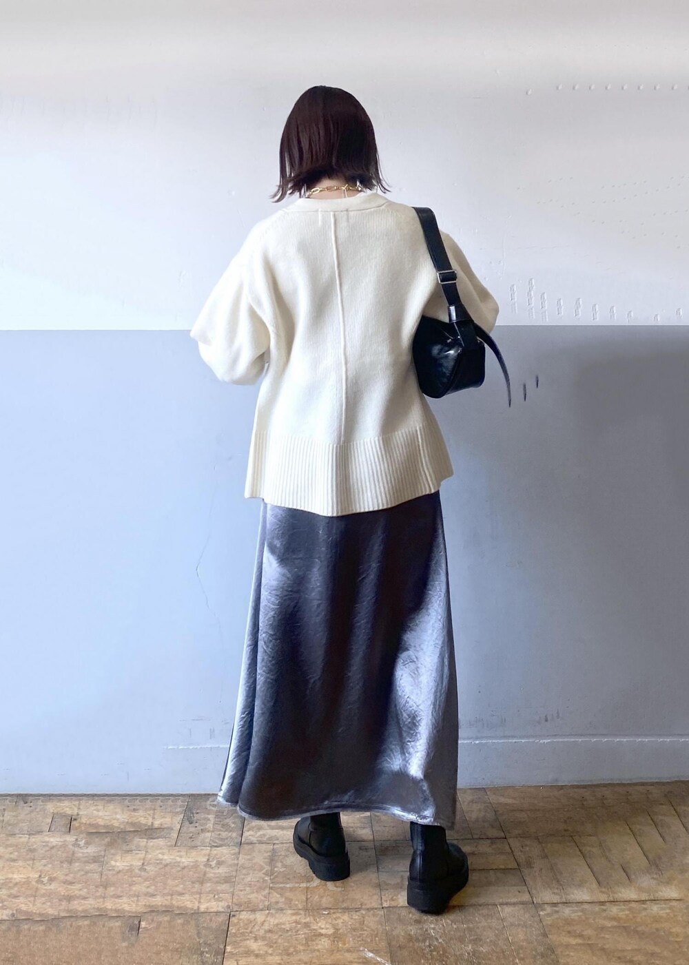 ホワイト系のTシャツ/カットソー、ブラック系のブーツ、ホワイト系のカーディガン/ボレロを着用したレディースの冬コーディネートの2枚目の写真