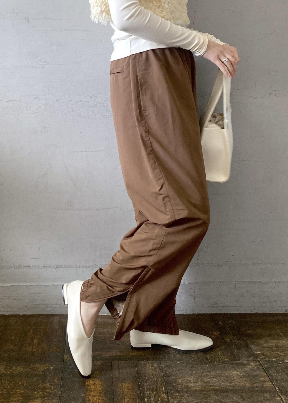 ホワイト系のハンドバッグを着用したレディースの冬コーディネートの6枚目の写真