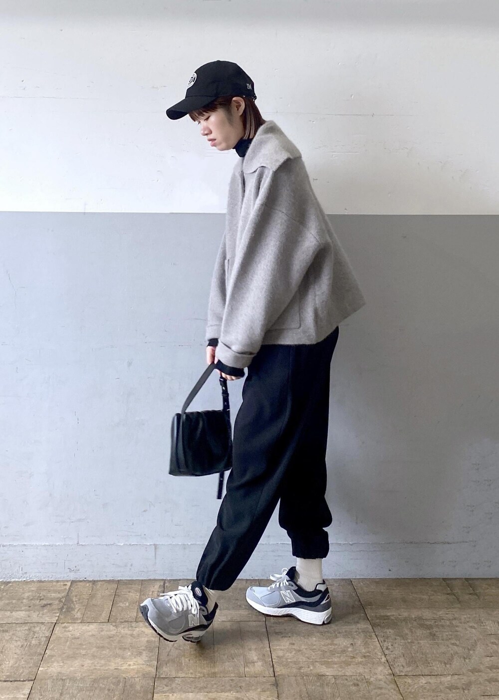 ブラック系のニット/セーター、ベージュ系のカーディガン/ボレロ、ブラック系のハンドバッグを着用したレディースの秋コーディネートの4枚目の写真