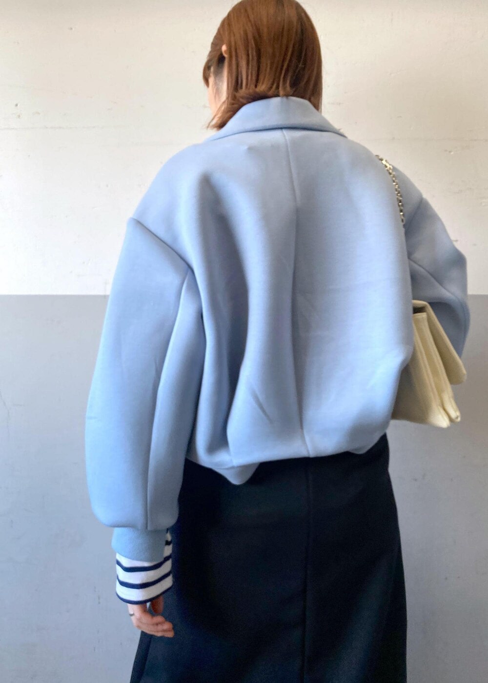 ブラック系のブーツ、ブラック系のスカート、ホワイト系のショルダーバッグを着用したレディースの秋コーディネートの9枚目の写真