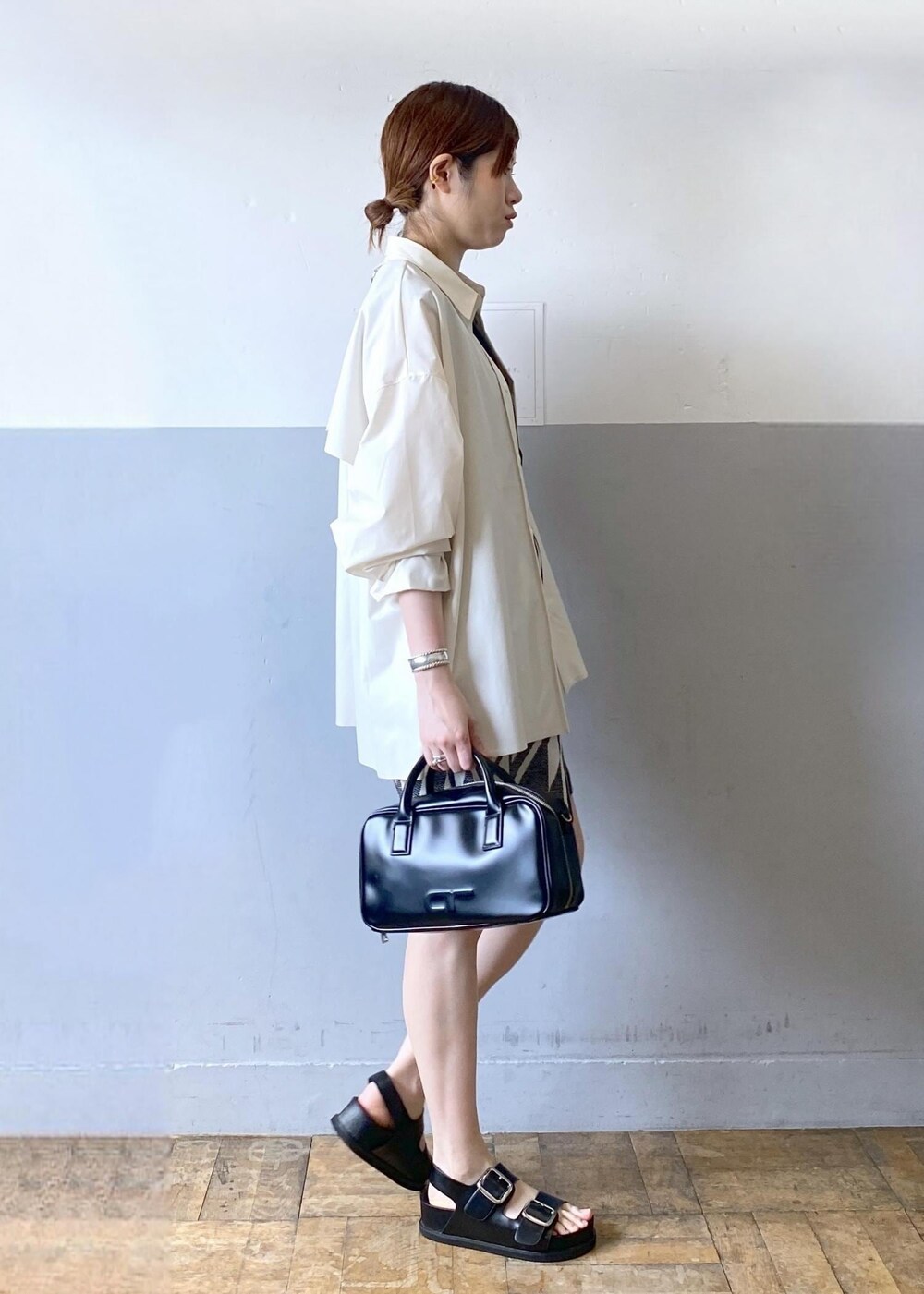 ブラック系のサンダル、ブラック系のボストンバッグ、ブラック系のタンクトップを着用したレディースの春コーディネートの5枚目の写真