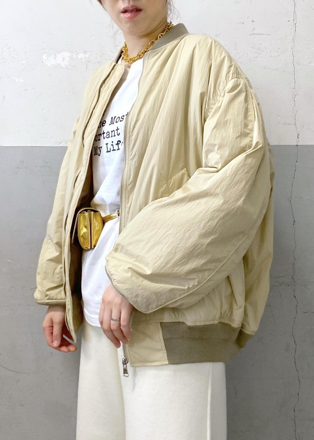 ホワイト系のTシャツ/カットソー、ベージュ系のMA-1、ホワイト系のその他パンツを着用したレディースの秋コーディネートの10枚目の写真