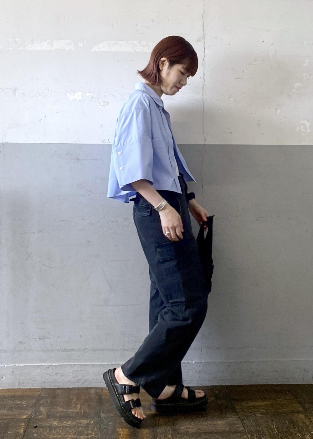 ホワイト系のタンクトップ、ブラック系のカーゴパンツ、ブラック系のトートバッグを着用したレディースの夏コーディネートの3枚目の写真