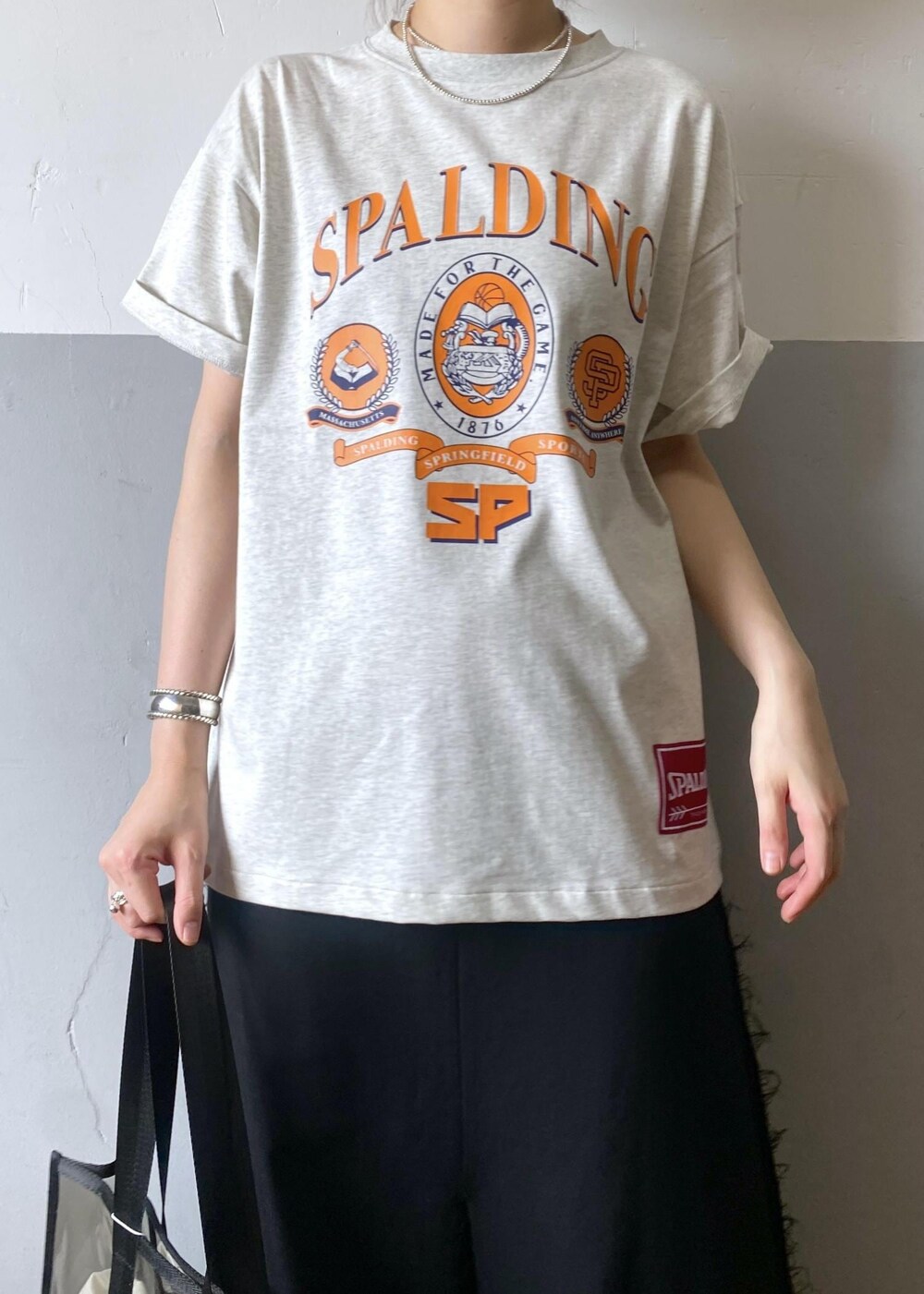 シルバー系のサンダル、ブラック系のトートバッグ、グレー系のTシャツ/カットソーを着用したレディースの夏コーディネートの5枚目の写真