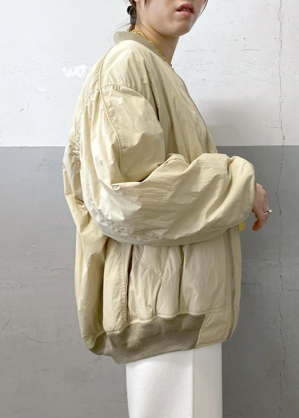 ホワイト系のTシャツ/カットソー、ベージュ系のMA-1、ホワイト系のその他パンツを着用したレディースの秋コーディネートの7枚目の写真