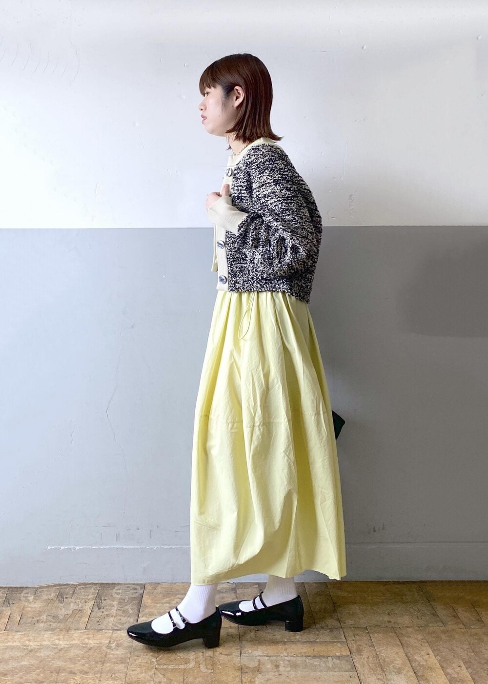 ブラック系のパンプス、ブラック系のショルダーバッグ、ベージュ系のカーディガン/ボレロを着用したレディースの春コーディネートの4枚目の写真