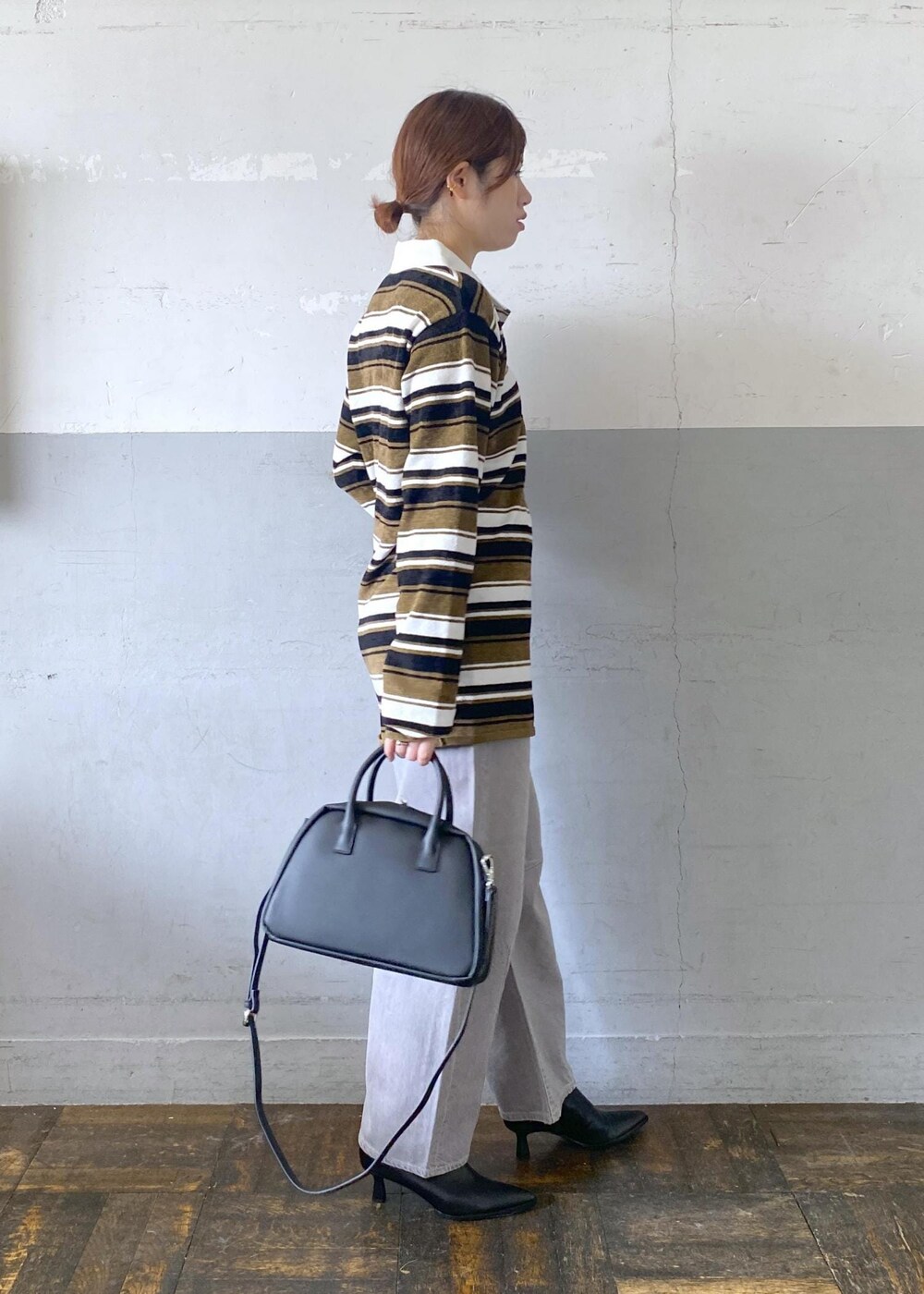 ブラック系のブーツ、ブラック系のボストンバッグ、グリーン系のワンピースを着用したレディースの秋コーディネートの5枚目の写真