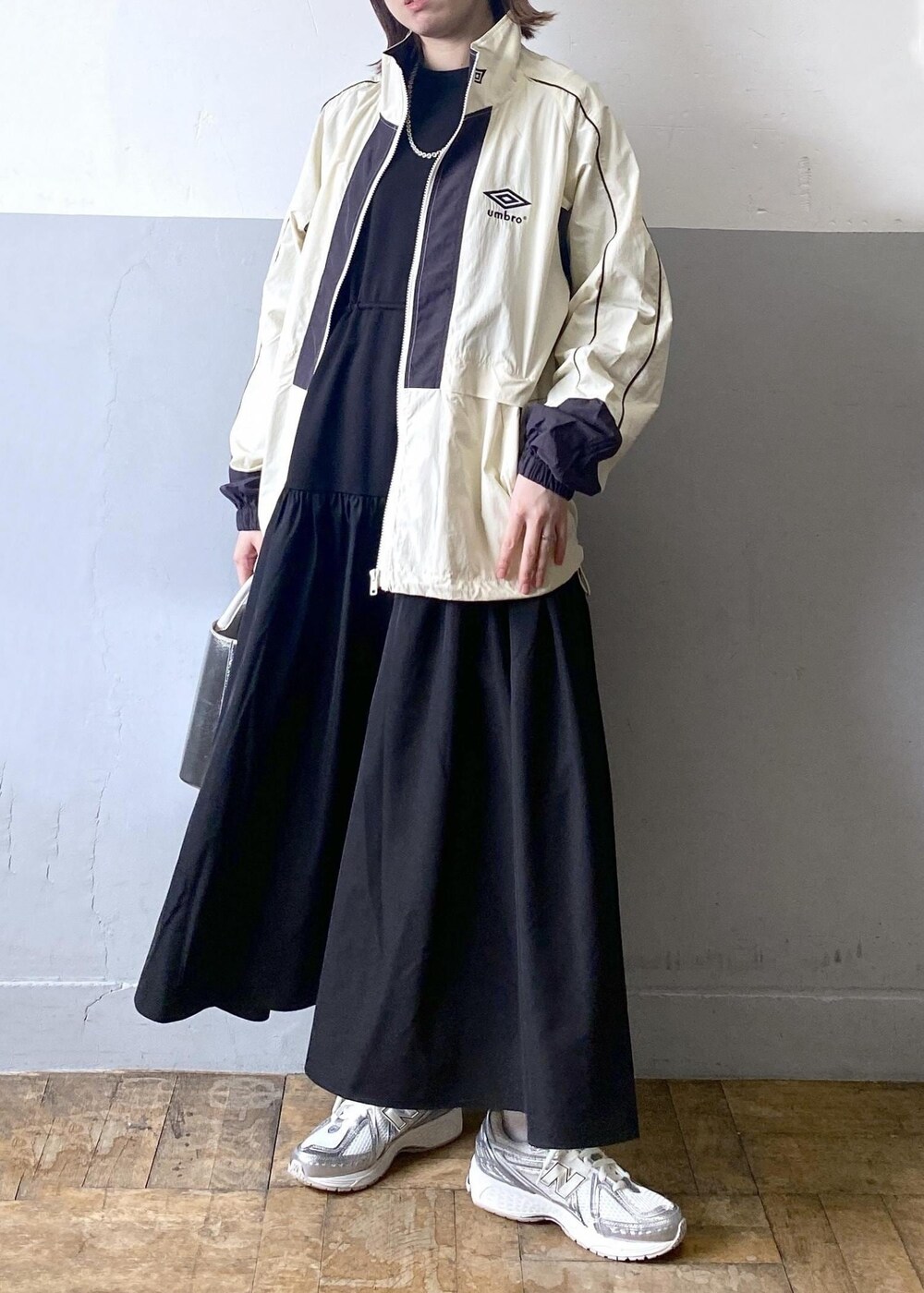 シルバー系のショルダーバッグ、ホワイト系のその他アウター、ブラック系のワンピースを着用したレディースの冬コーディネートの3枚目の写真