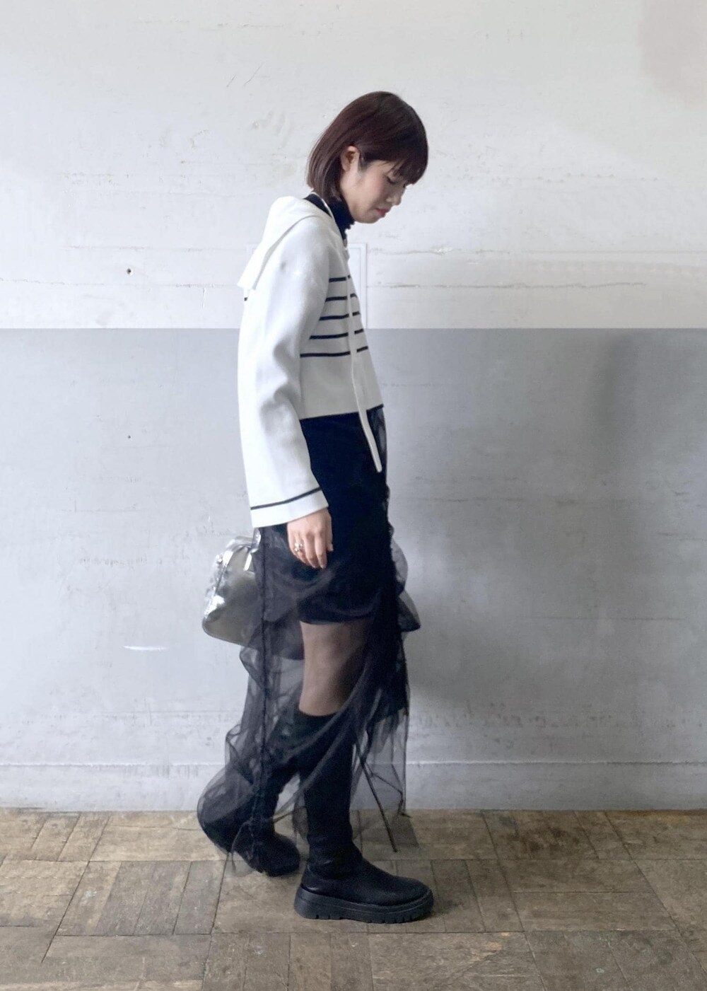 シルバー系のボストンバッグ、ブラック系のニット/セーターを着用したレディースの冬コーディネートの4枚目の写真