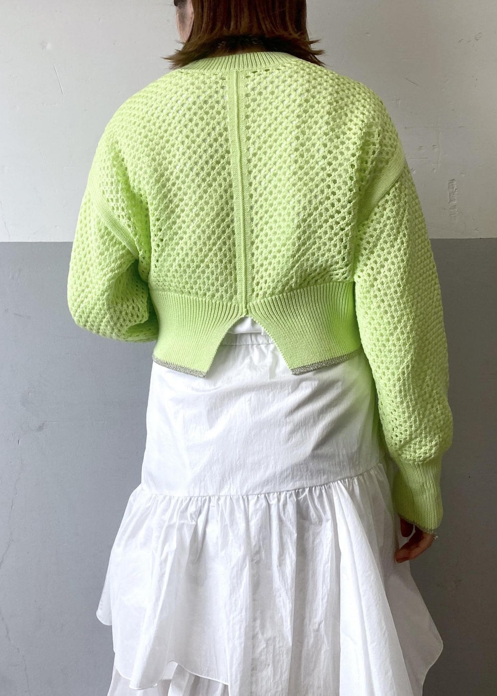 ホワイト系のスカート、ブラック系のブルゾン、グリーン系のニット/セーターを着用したレディースの春コーディネートの8枚目の写真