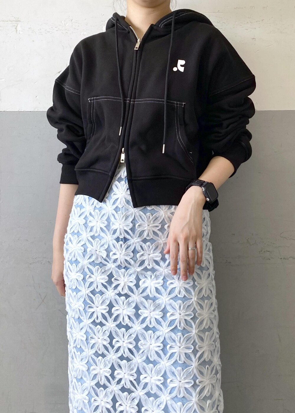 ブラック系のショルダーバッグ、ホワイト系のスカートを着用したレディースの夏コーディネートの6枚目の写真