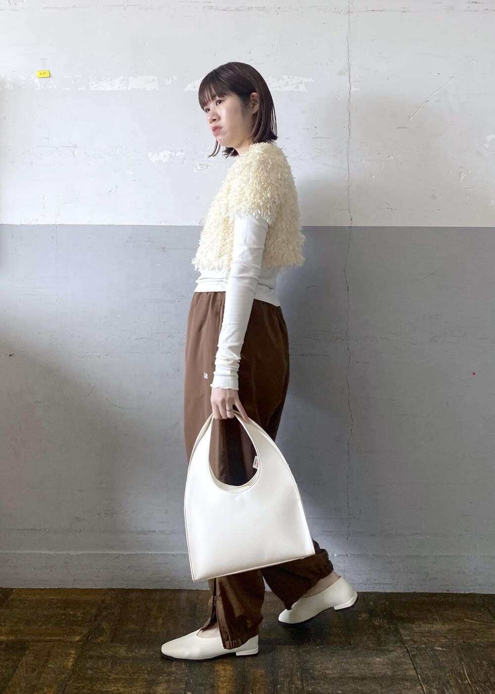 ホワイト系のハンドバッグを着用したレディースの冬コーディネートの2枚目の写真