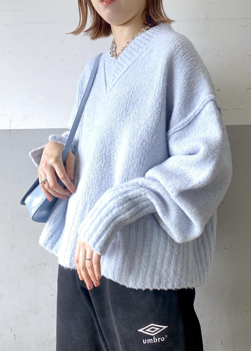ブルー系のニット/セーター、ブラック系のその他パンツ、ブルー系のショルダーバッグを着用したレディースの秋コーディネートの7枚目の写真