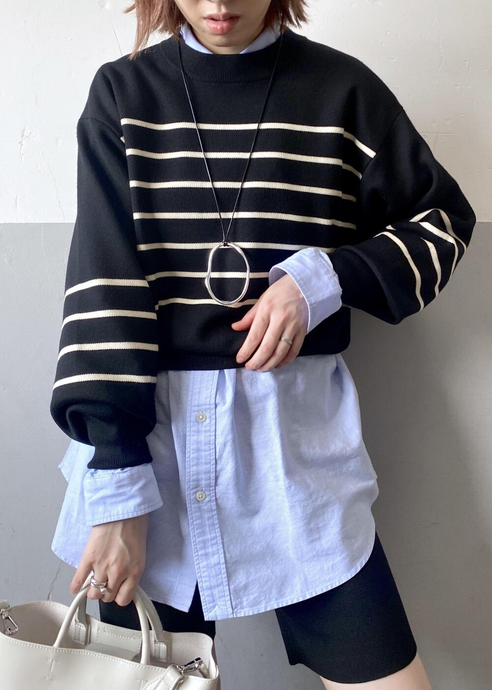 ホワイト系のトートバッグ、ブラック系のニット/セーター、ブルー系のシャツ/ブラウスを着用したレディースの秋コーディネートの6枚目の写真