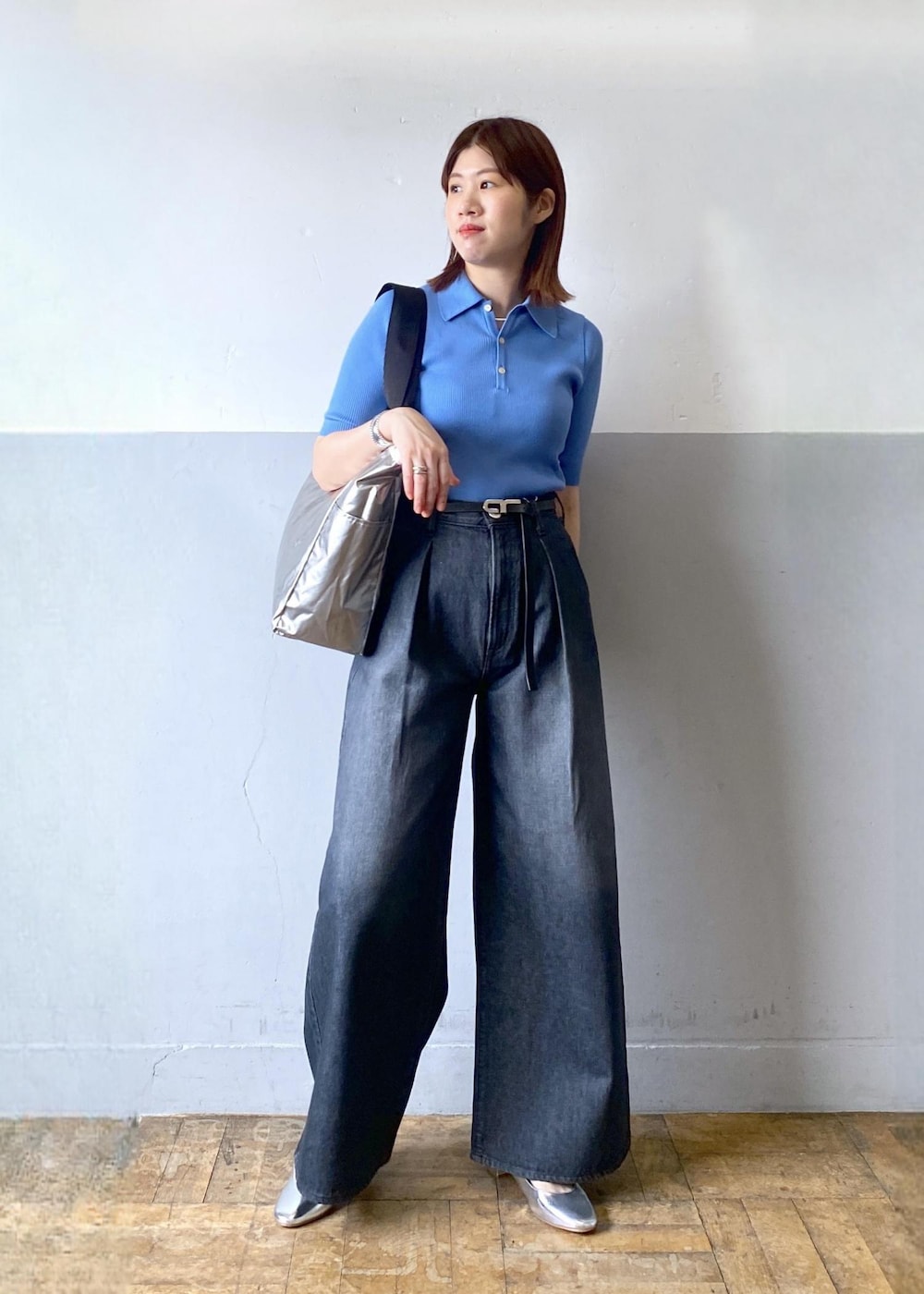 シルバー系のパンプス、ブラック系のデニムパンツ、ブラック系のトートバッグを着用したレディースの春コーディネートの2枚目の写真