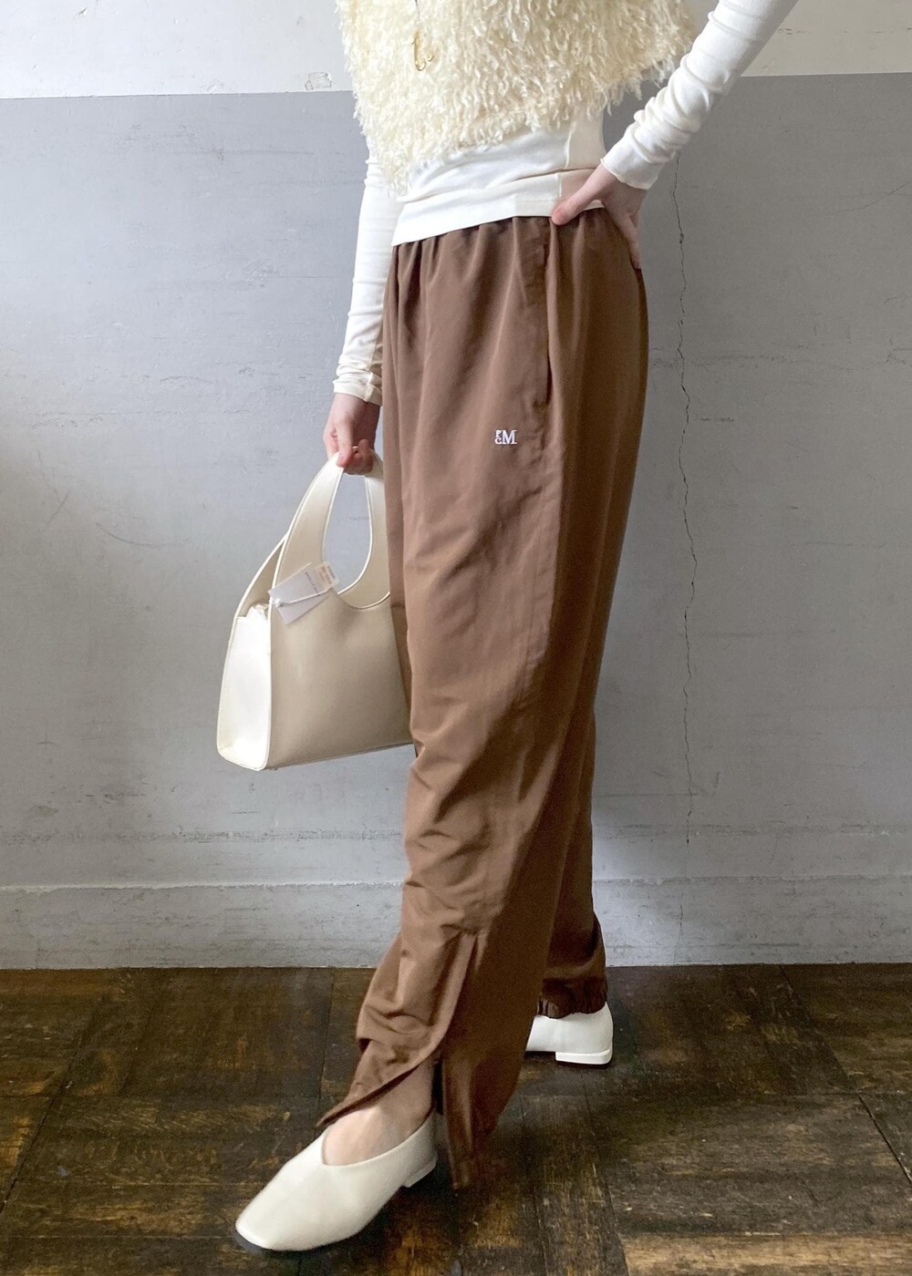 ホワイト系のハンドバッグを着用したレディースの冬コーディネートの7枚目の写真