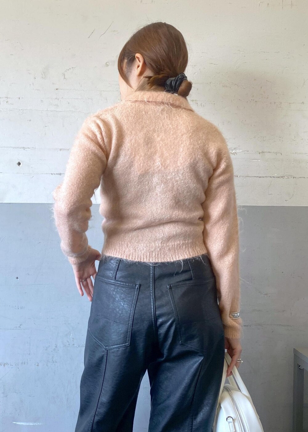 ホワイト系のボストンバッグ、ホワイト系のブーツ、ブラック系のその他パンツを着用したレディースの秋コーディネートの7枚目の写真