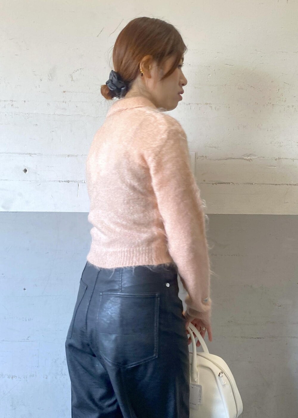 ホワイト系のボストンバッグ、ホワイト系のブーツ、ブラック系のその他パンツを着用したレディースの秋コーディネートの8枚目の写真