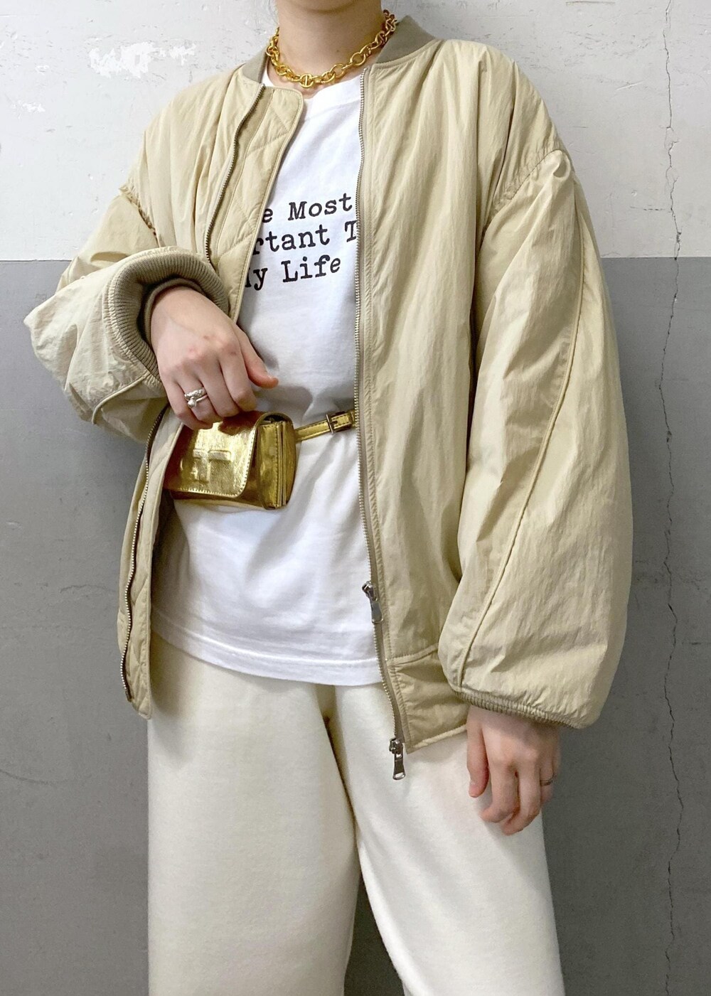 ホワイト系のTシャツ/カットソー、ベージュ系のMA-1、ホワイト系のその他パンツを着用したレディースの秋コーディネートの6枚目の写真