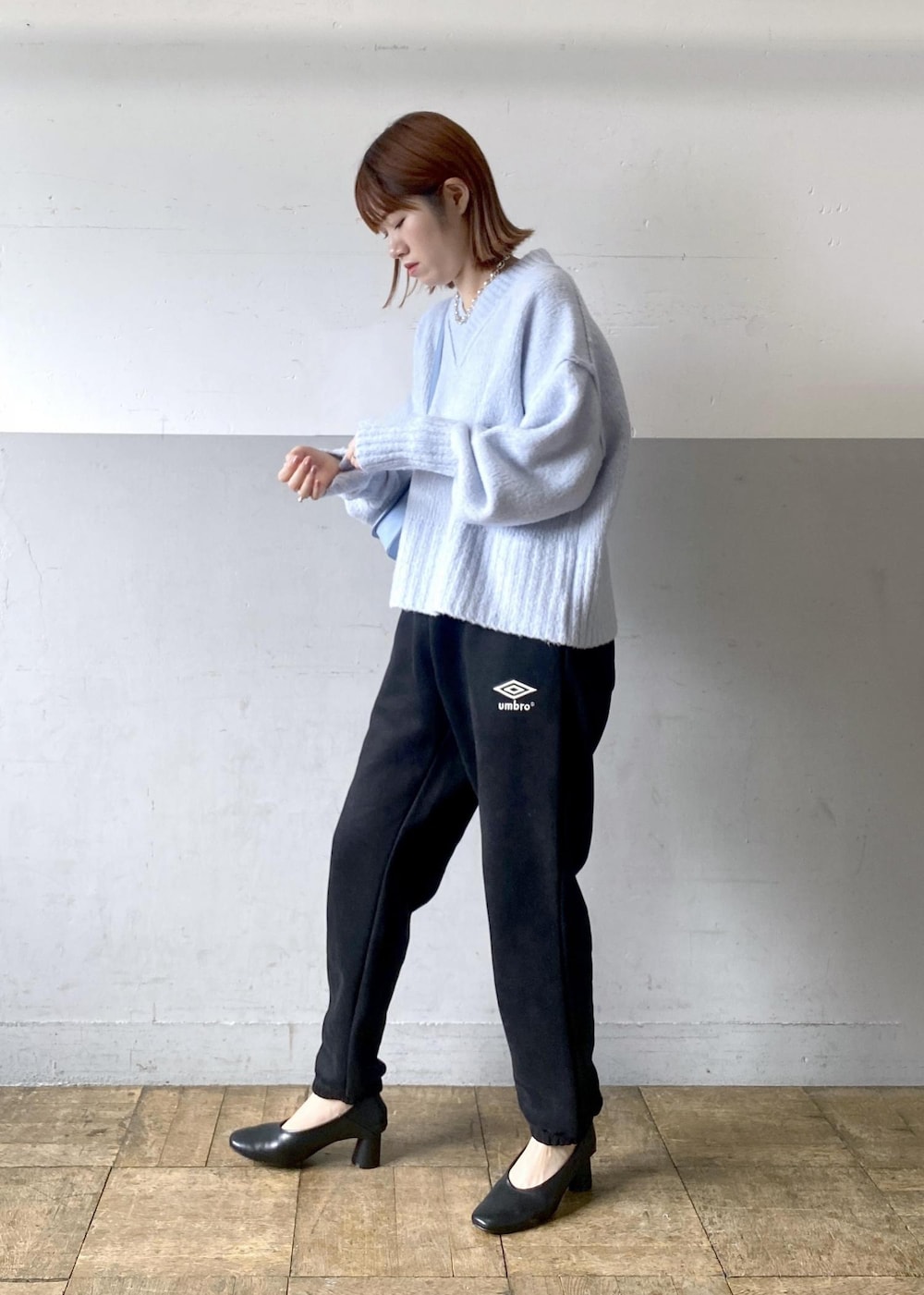 ブルー系のニット/セーター、ブラック系のその他パンツ、ブルー系のショルダーバッグを着用したレディースの秋コーディネートの4枚目の写真