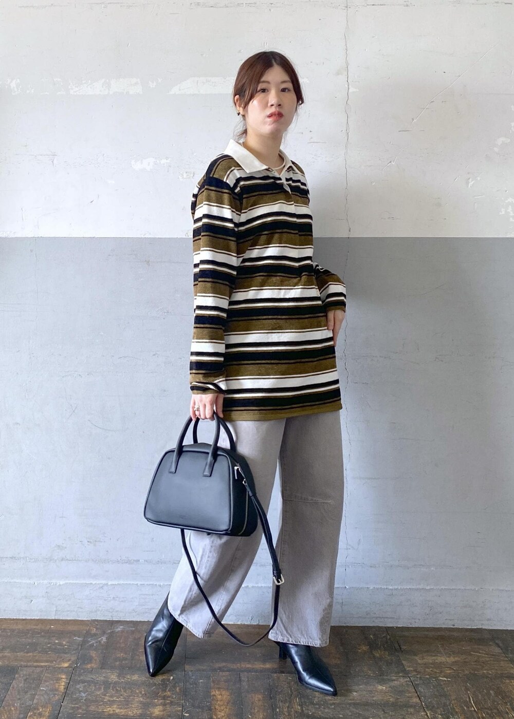 ブラック系のブーツ、ブラック系のボストンバッグ、グリーン系のワンピースを着用したレディースの秋コーディネートの6枚目の写真