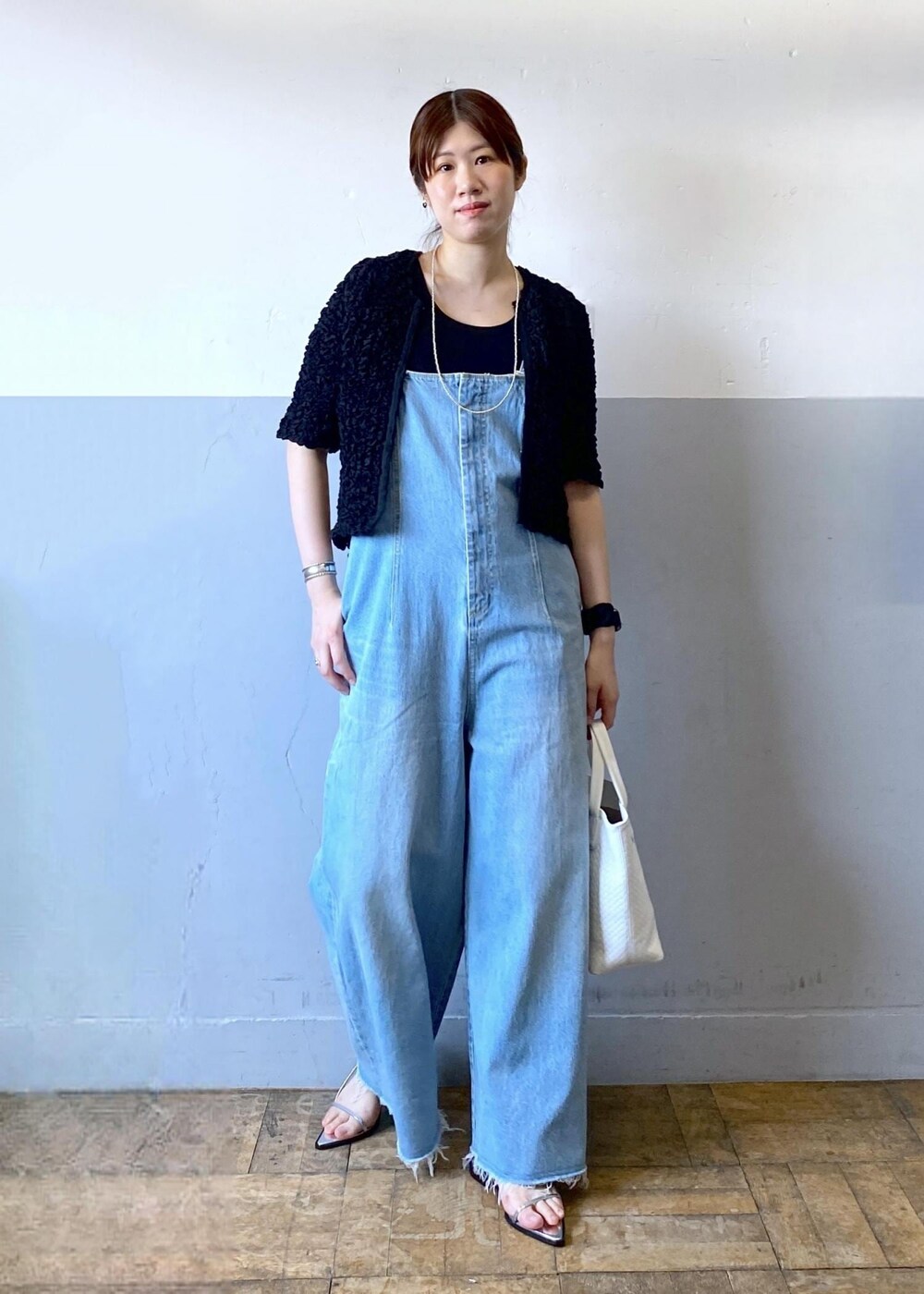 シルバー系のサンダル、ブルー系のサロペット/オーバーオール、ブラック系のカーディガン/ボレロを着用したレディースの春コーディネートの2枚目の写真