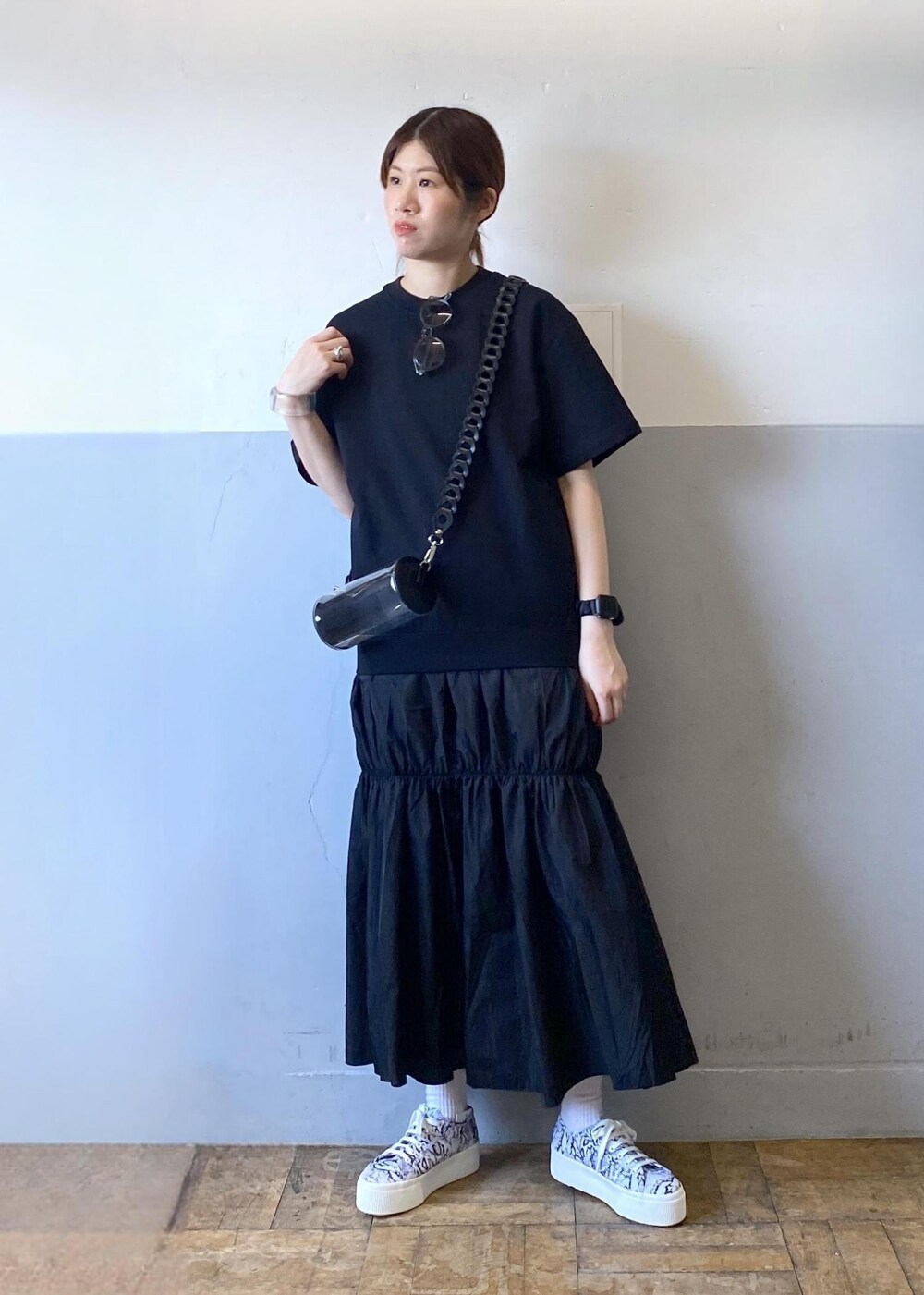 ブラック系のスニーカー、ブラック系のドラムバッグ、ブラック系のワンピースを着用したレディースの夏コーディネートの9枚目の写真