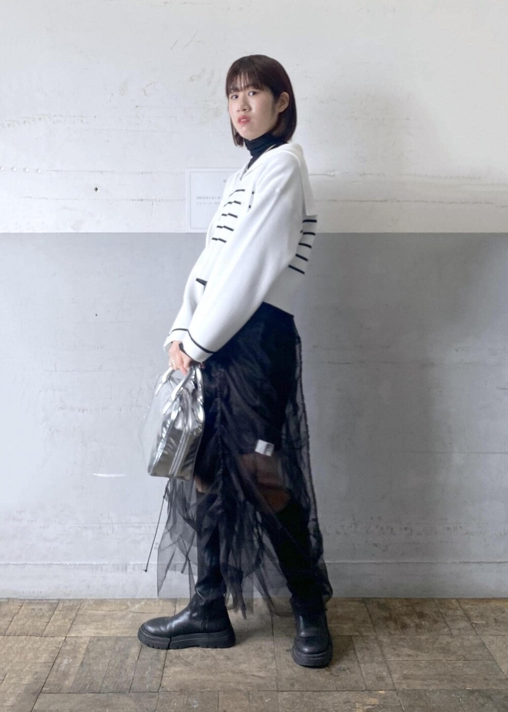 シルバー系のボストンバッグ、ブラック系のニット/セーターを着用したレディースの冬コーディネートの10枚目の写真