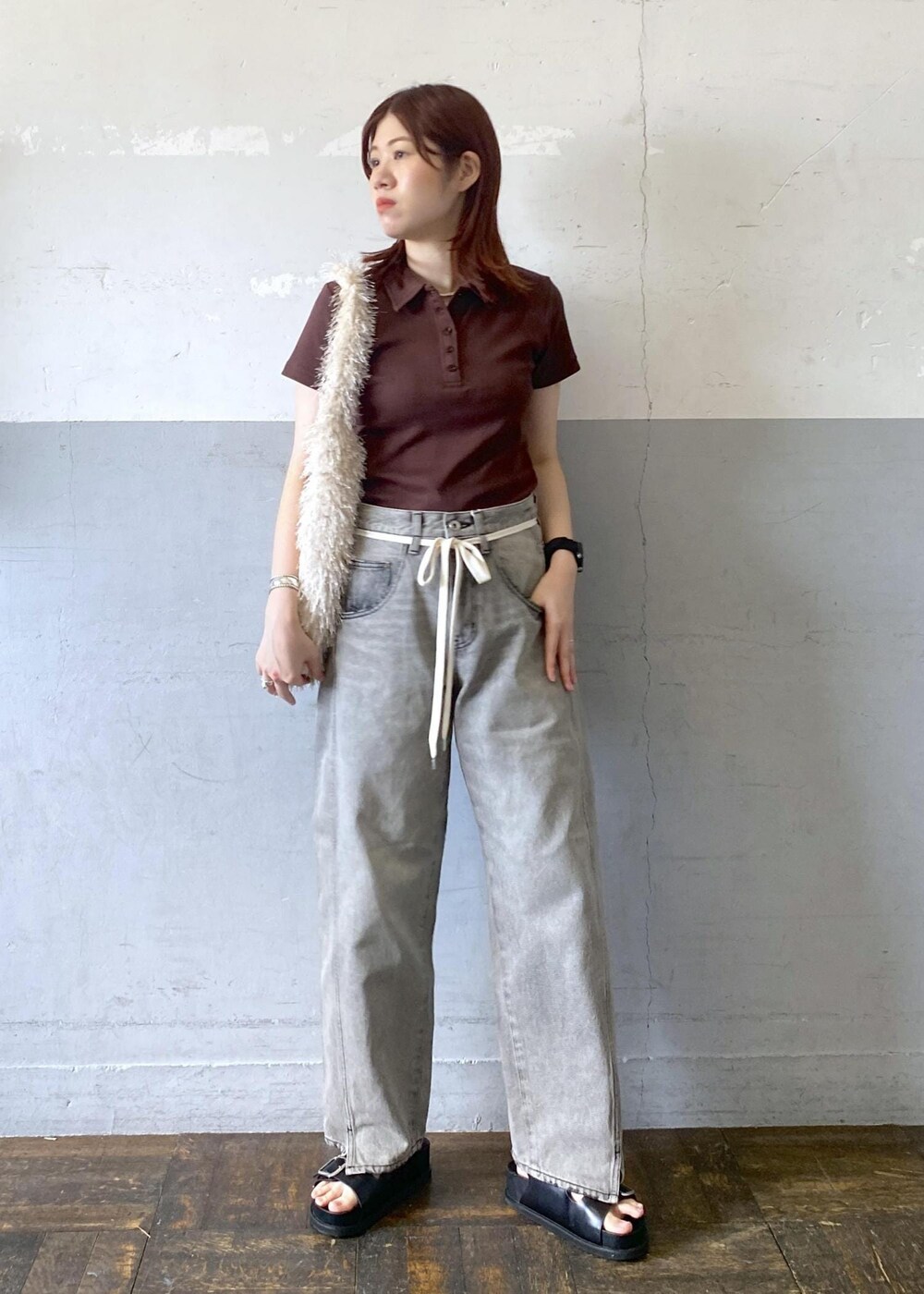 ブラック系のサンダル、ブラウン系のTシャツ/カットソー、ブラック系のデニムパンツを着用したレディースの夏コーディネートの2枚目の写真