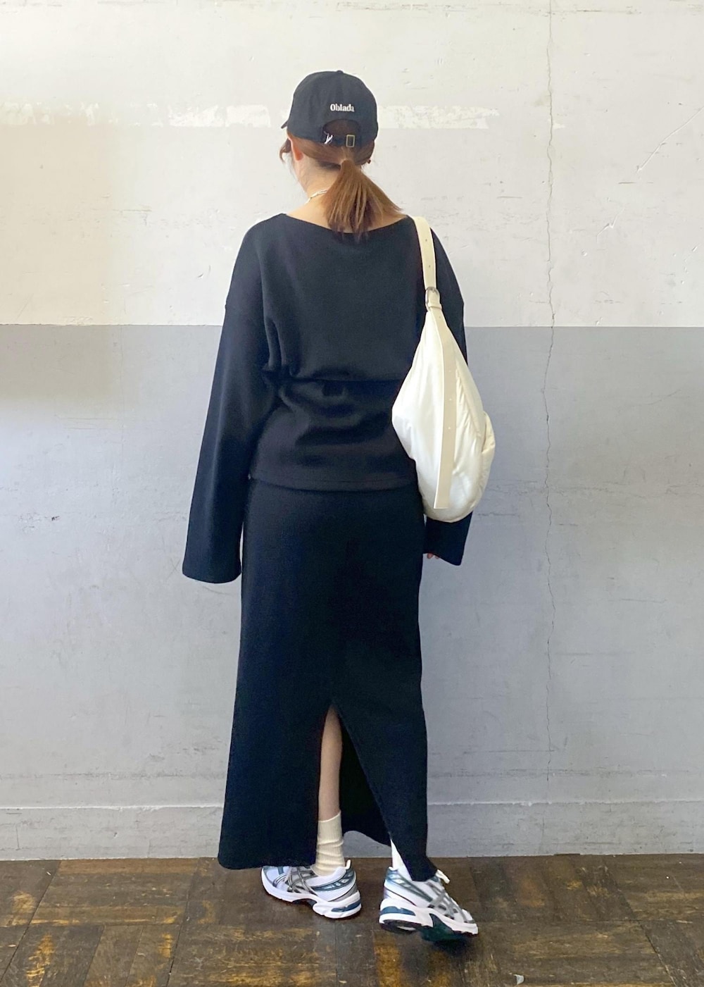 ホワイト系のショルダーバッグ、ブラック系のTシャツ/カットソー、ブラック系のスカートを着用したレディースの秋コーディネートの5枚目の写真