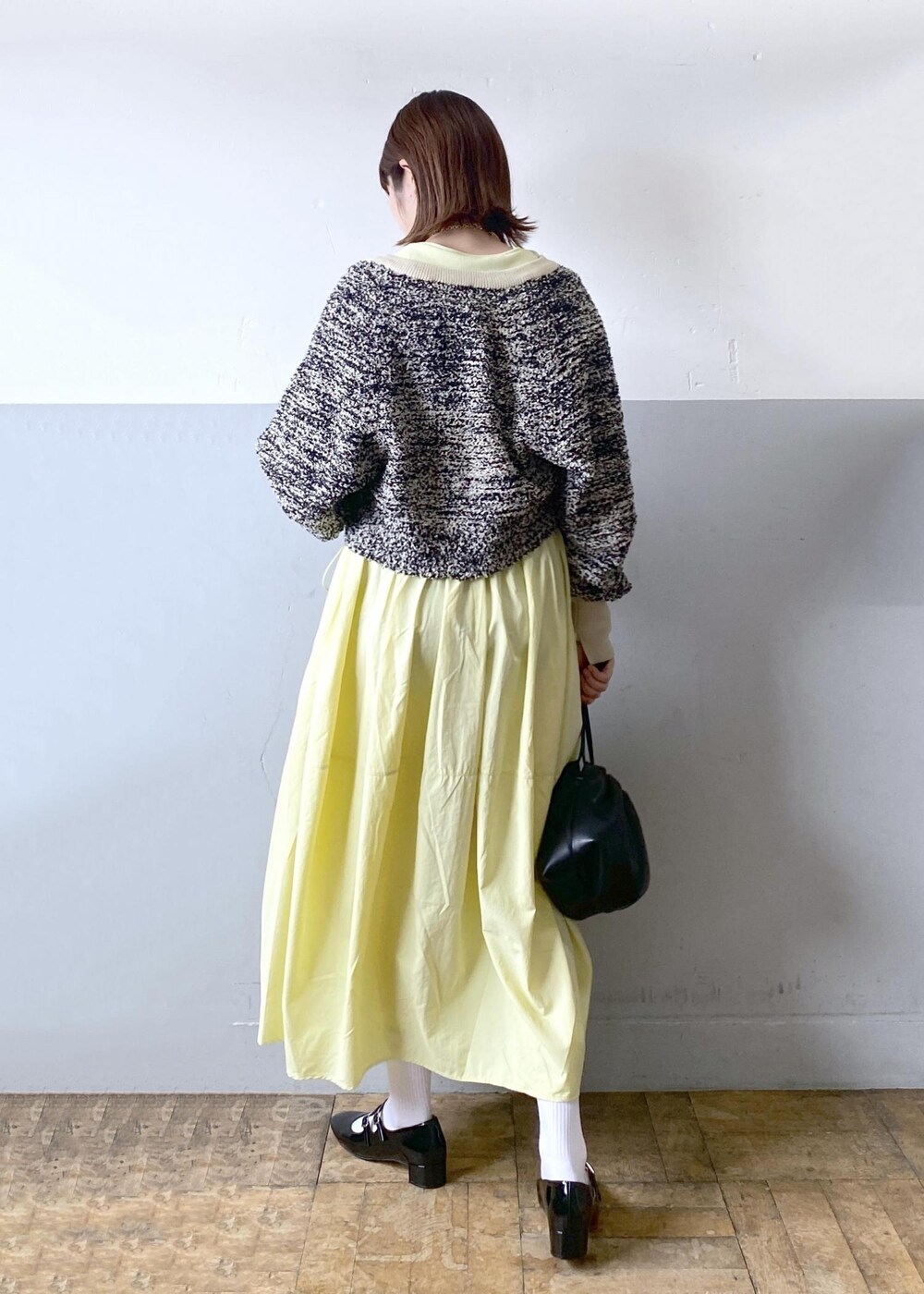 ブラック系のパンプス、ブラック系のショルダーバッグ、ベージュ系のカーディガン/ボレロを着用したレディースの春コーディネートの5枚目の写真