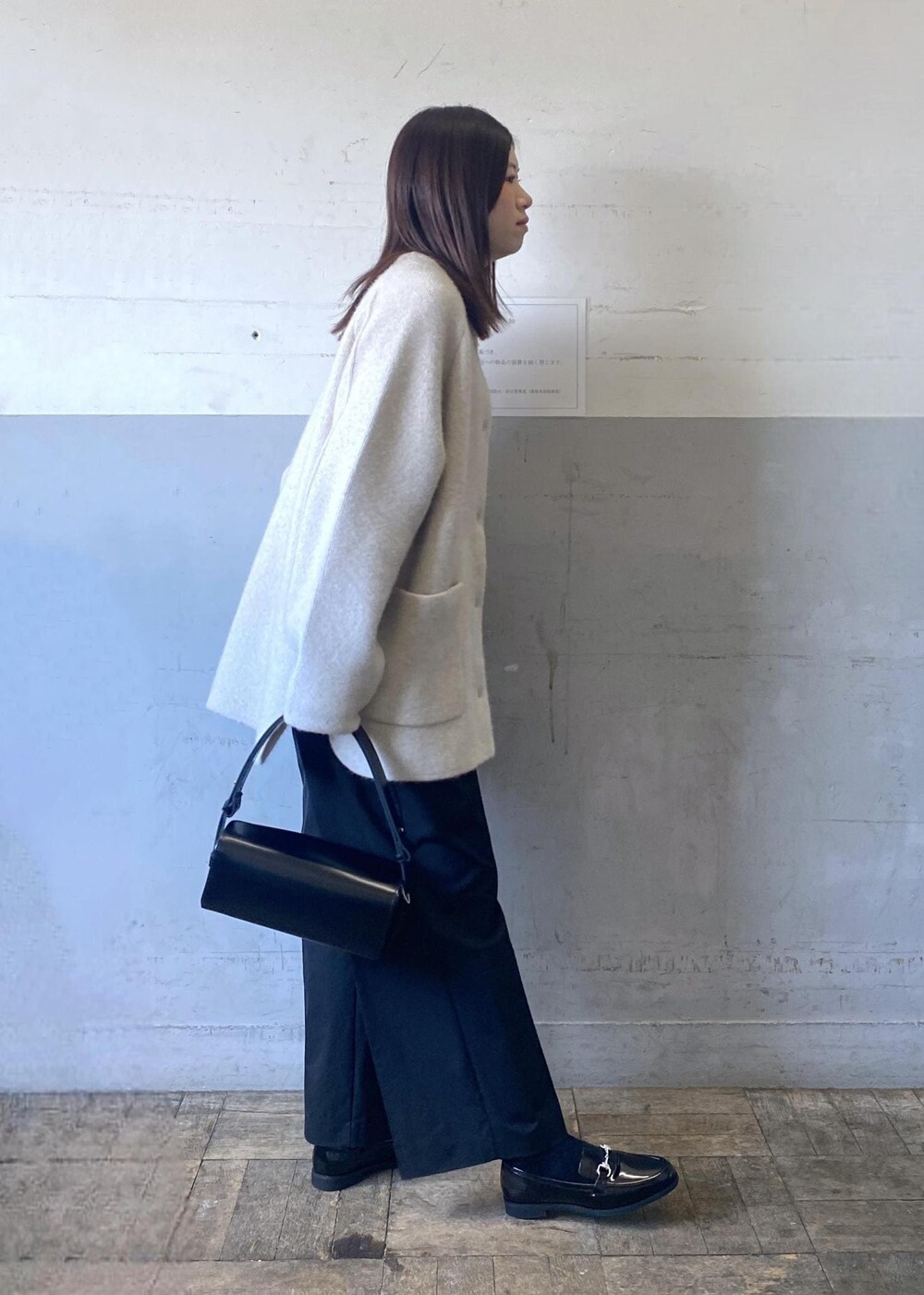 ホワイト系のカーディガン/ボレロ、ホワイト系のニット/セーター、ブラック系のハンドバッグを着用したレディースの冬コーディネートの3枚目の写真