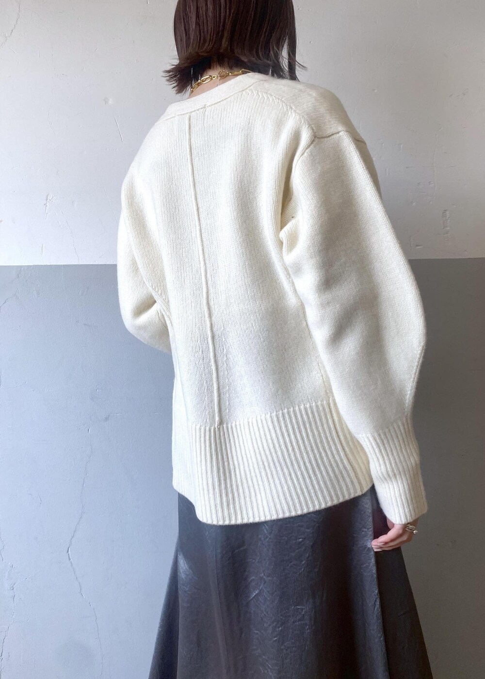 ホワイト系のTシャツ/カットソー、ブラック系のブーツ、ホワイト系のカーディガン/ボレロを着用したレディースの冬コーディネートの6枚目の写真