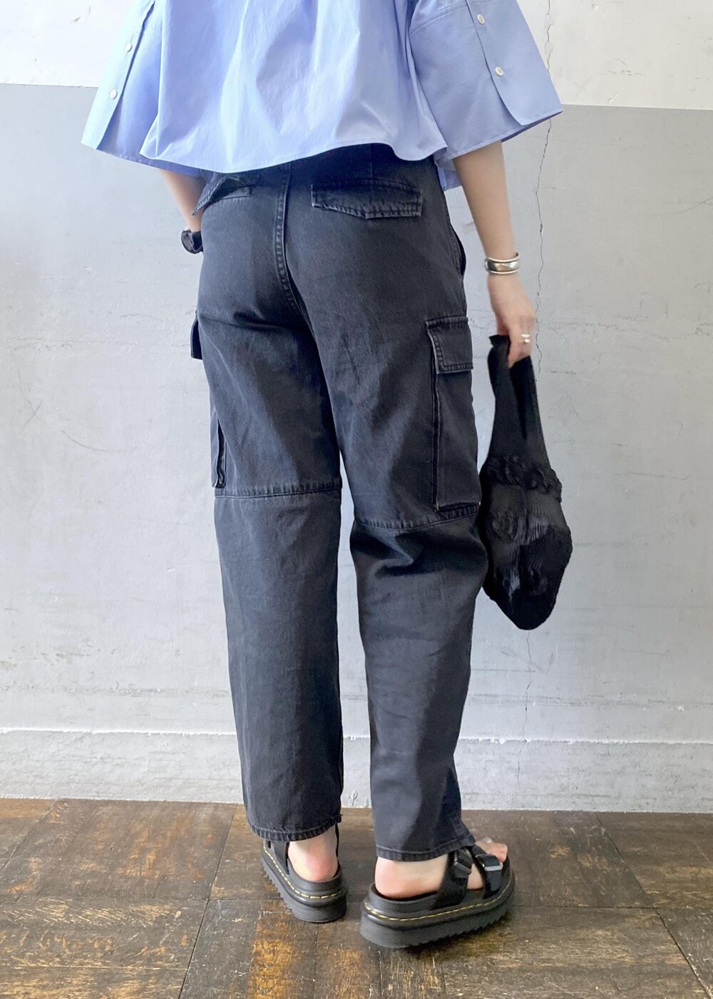 ホワイト系のタンクトップ、ブラック系のカーゴパンツ、ブラック系のトートバッグを着用したレディースの夏コーディネートの7枚目の写真