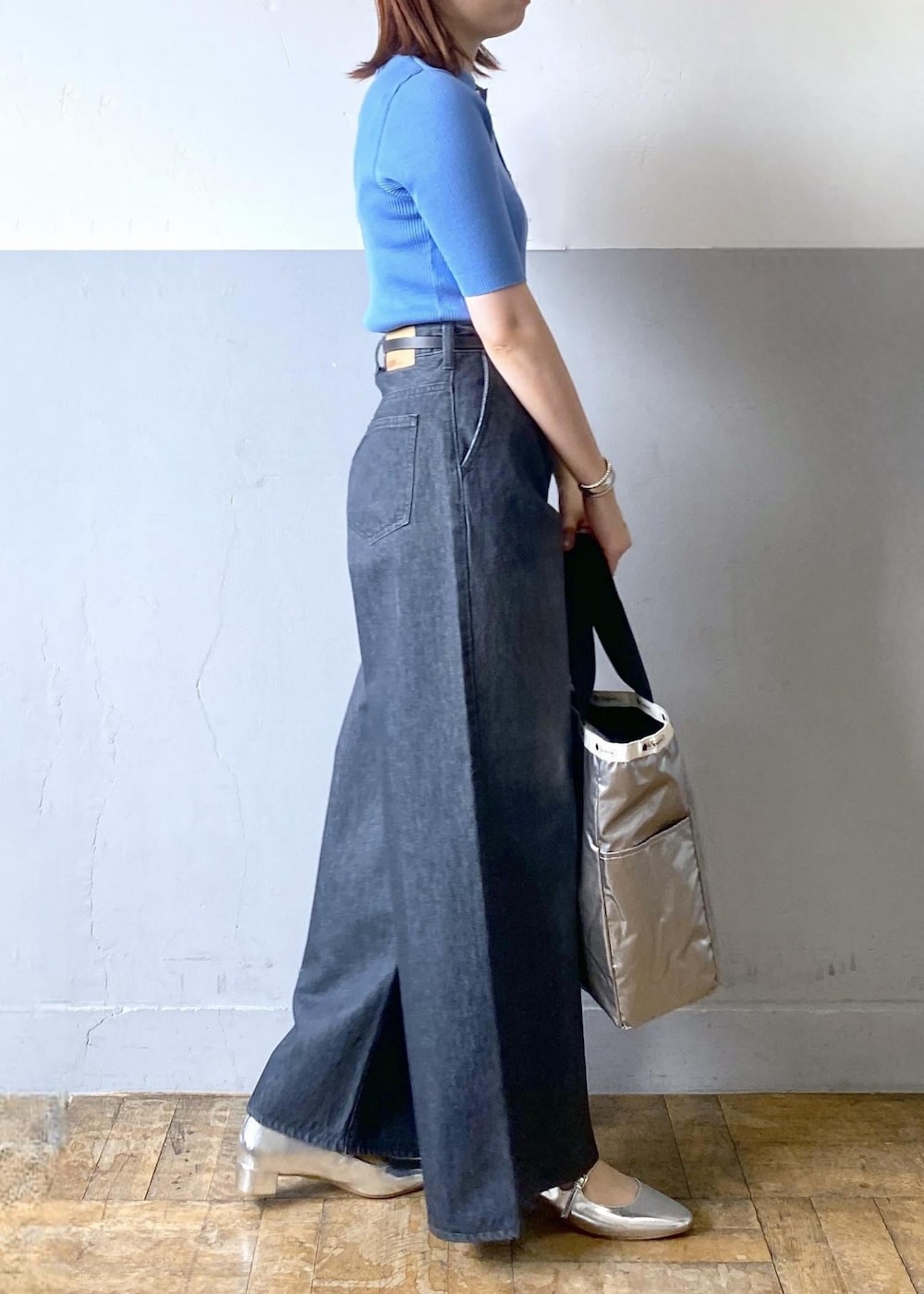 シルバー系のパンプス、ブラック系のデニムパンツ、ブラック系のトートバッグを着用したレディースの春コーディネートの3枚目の写真