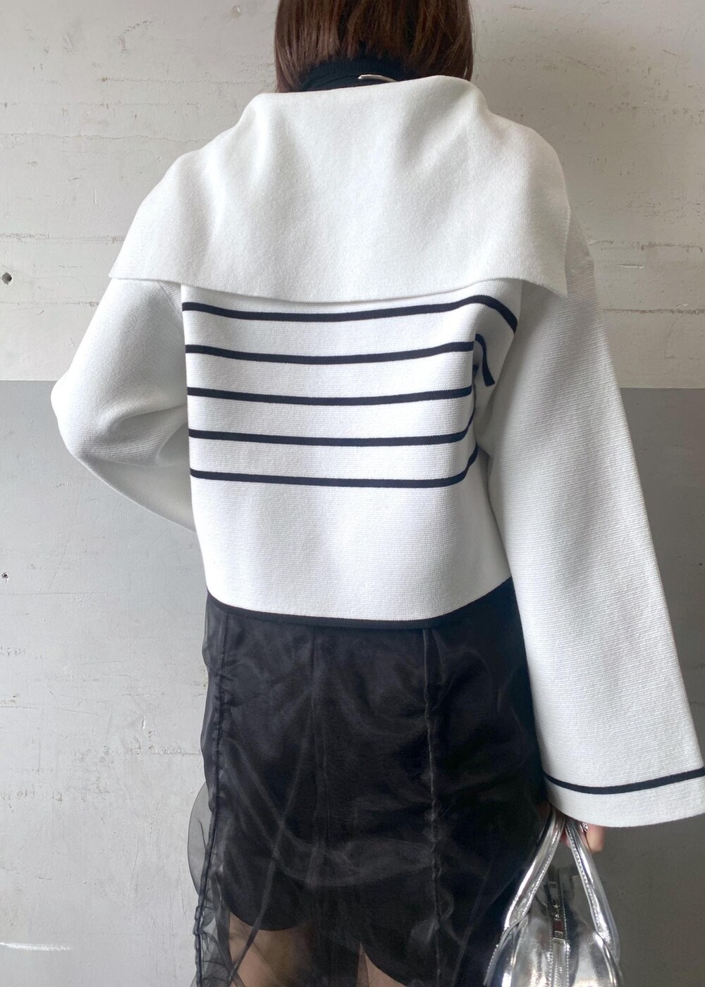 シルバー系のボストンバッグ、ブラック系のニット/セーターを着用したレディースの冬コーディネートの8枚目の写真