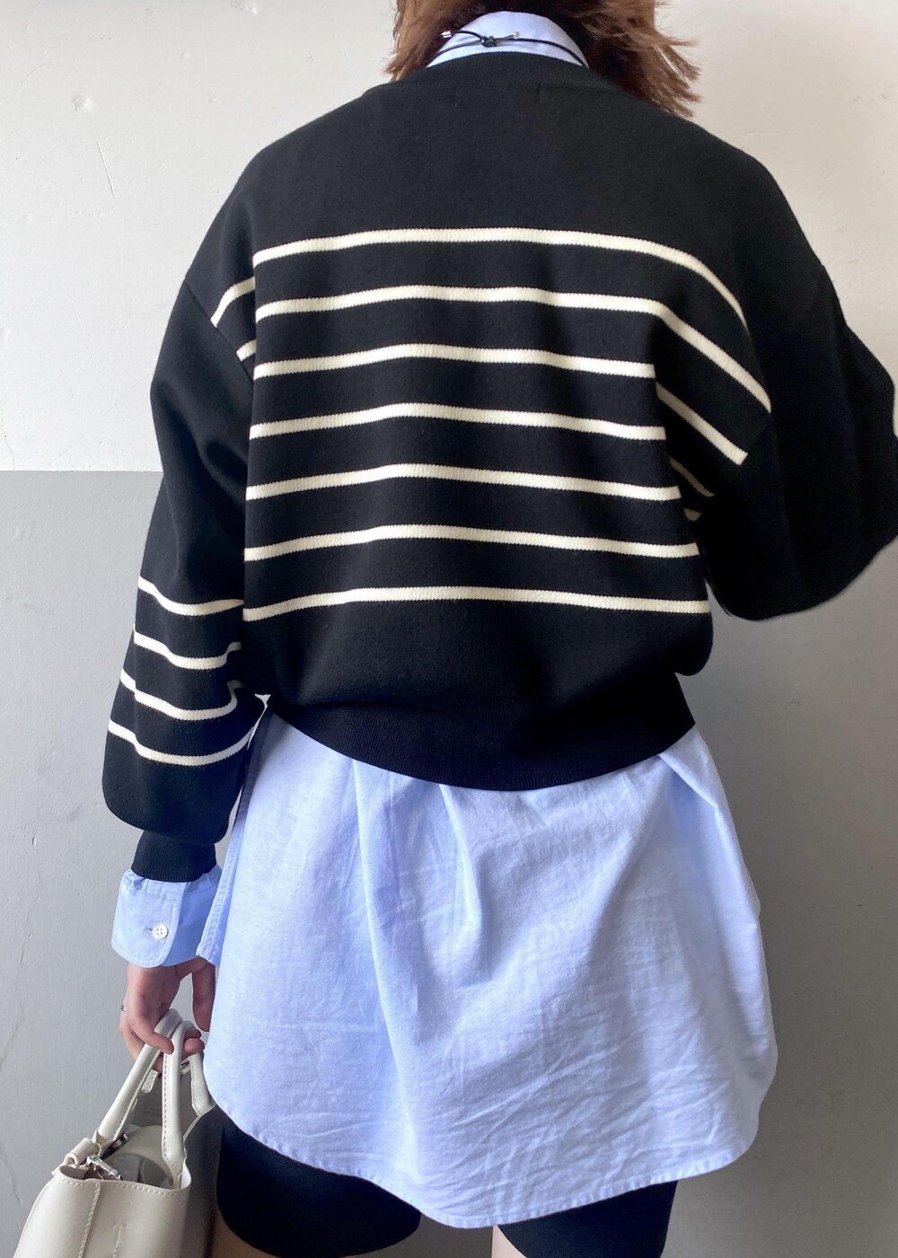 ホワイト系のトートバッグ、ブラック系のニット/セーター、ブルー系のシャツ/ブラウスを着用したレディースの秋コーディネートの8枚目の写真