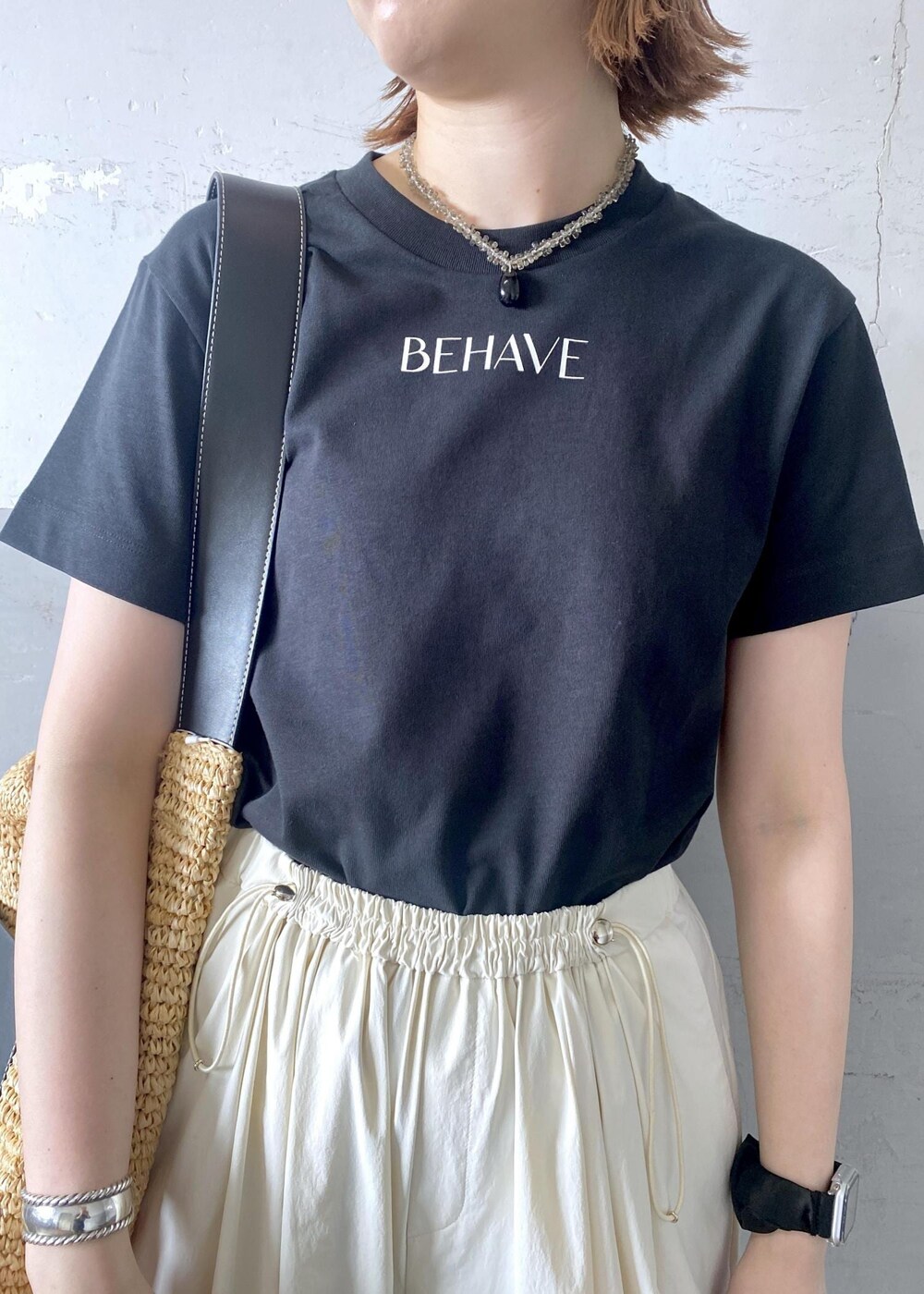 ベージュ系のトートバッグ、ブラック系のTシャツ/カットソー、ブラック系のサンダルを着用したレディースの夏コーディネートの5枚目の写真