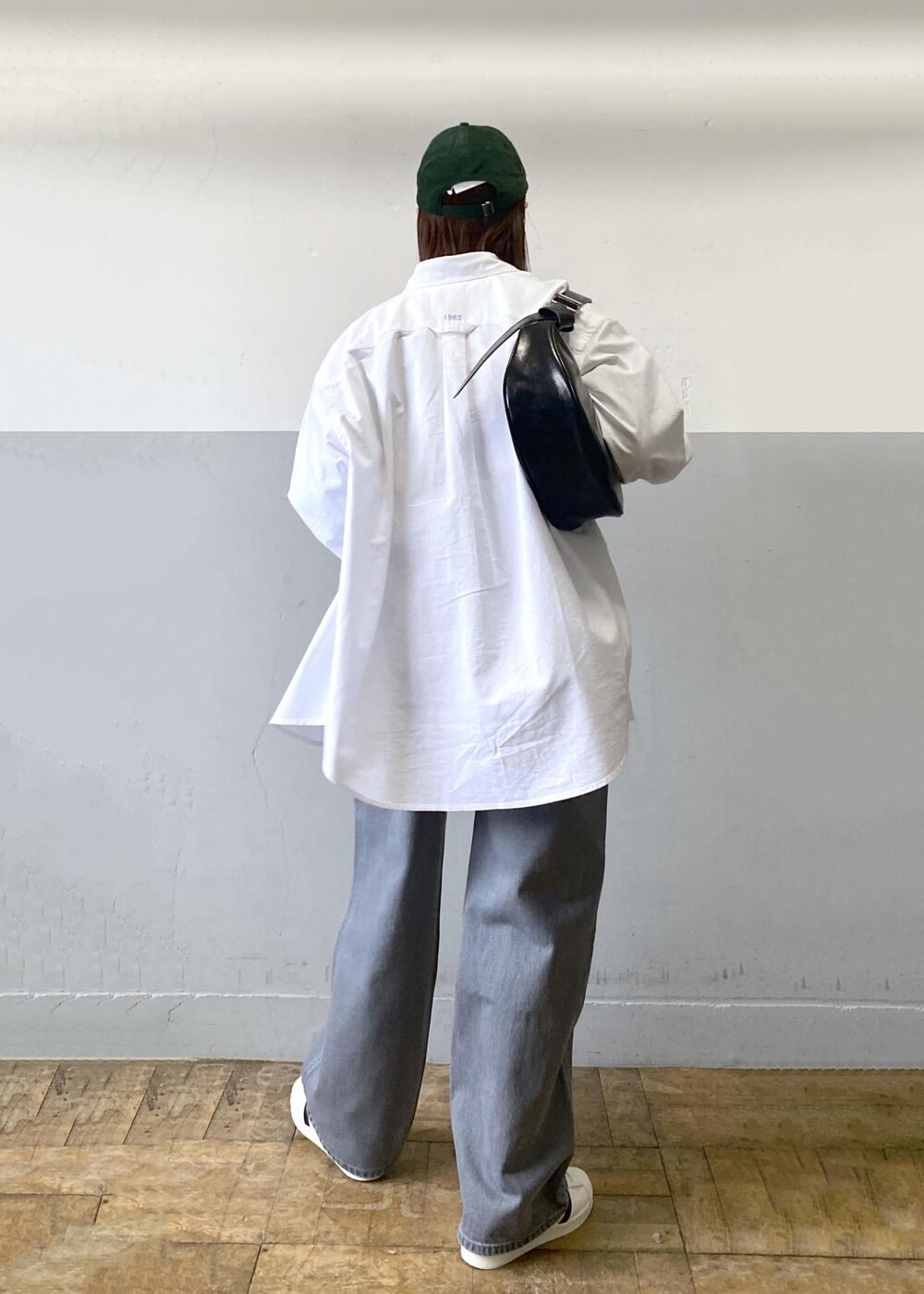 ブラック系のTシャツ/カットソー、ブラック系のショルダーバッグ、ホワイト系のシャツ/ブラウスを着用したレディースの冬コーディネートの5枚目の写真